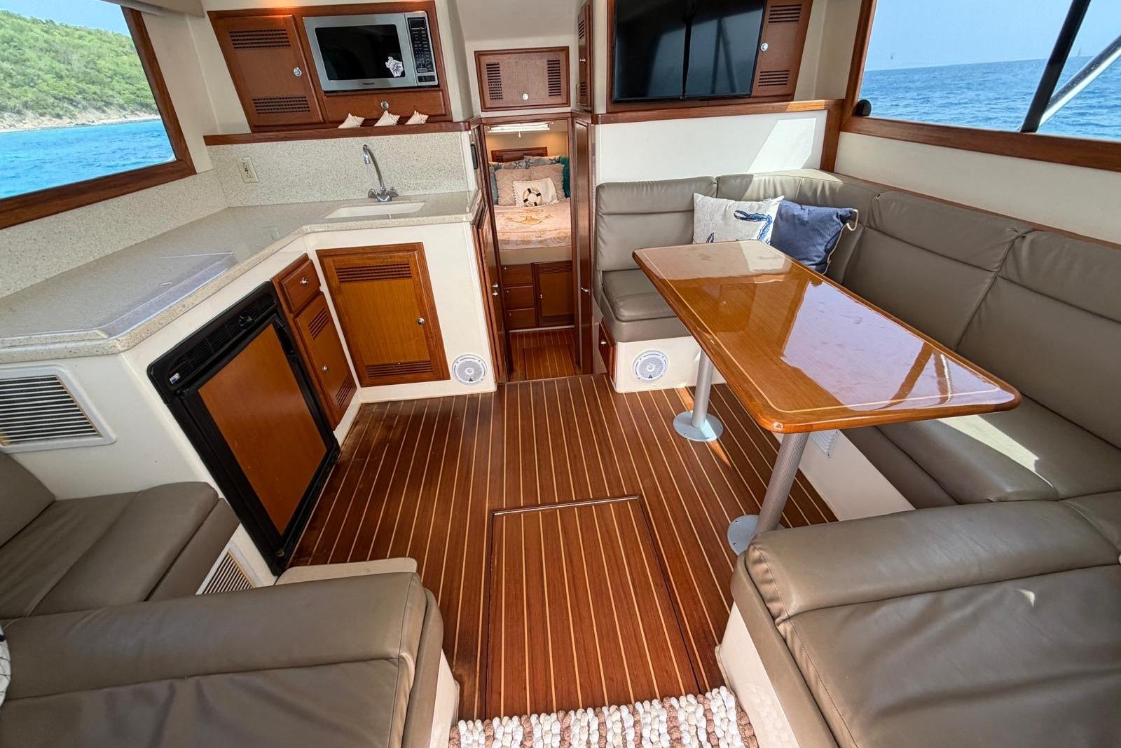 Interior of 2004 Cabo 35 Flybridge yacht with kitchen and seating area, ocean view.
