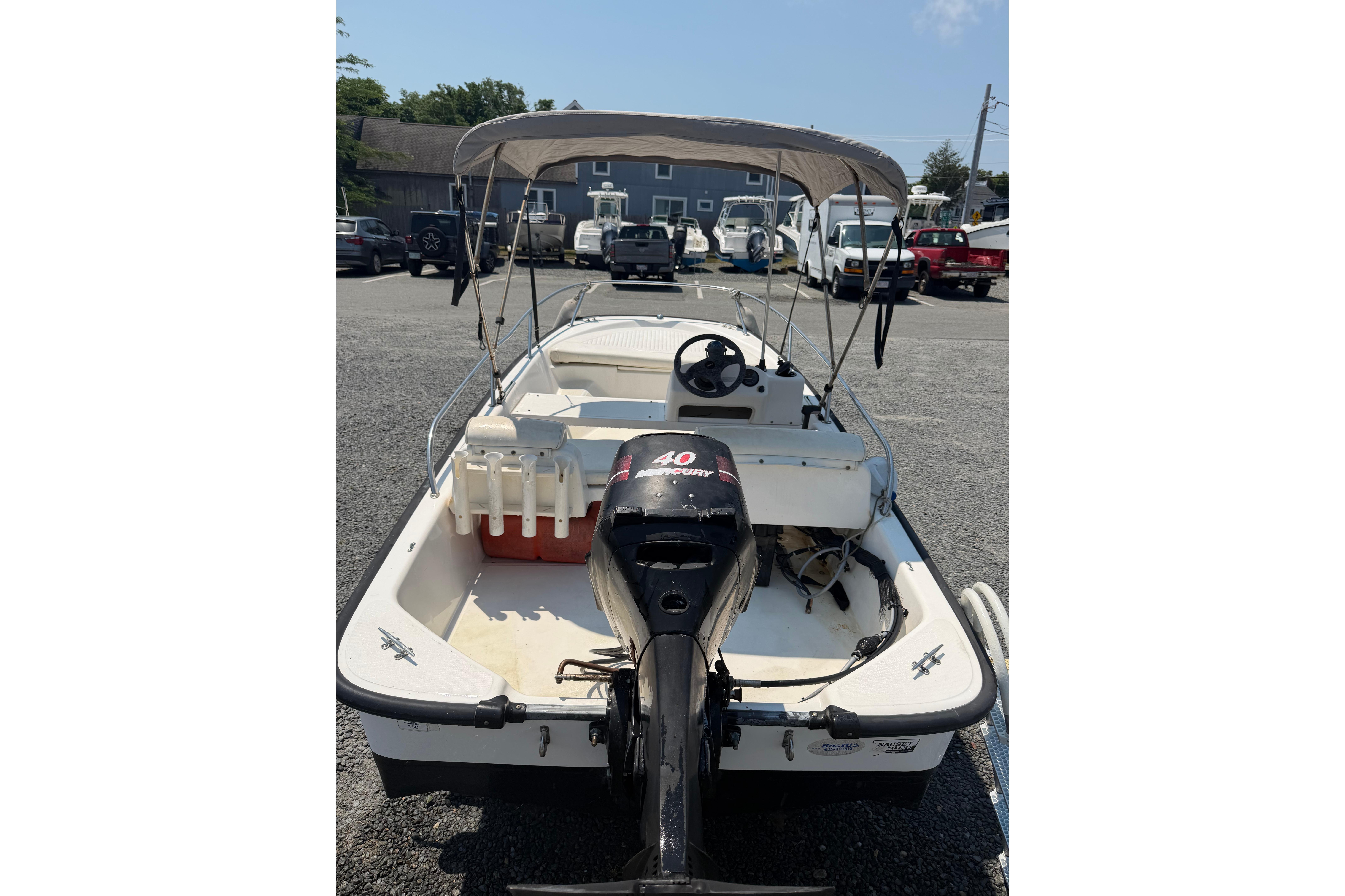 2003 Boston Whaler 130 Super Sport boat with canopy and Mercury 40 HP engine.