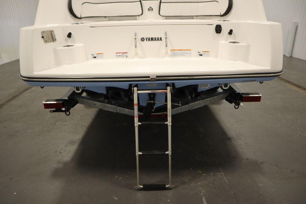 Rear view of 2026 Yamaha Boats 255 FSH Sport E with ladder and trailer.