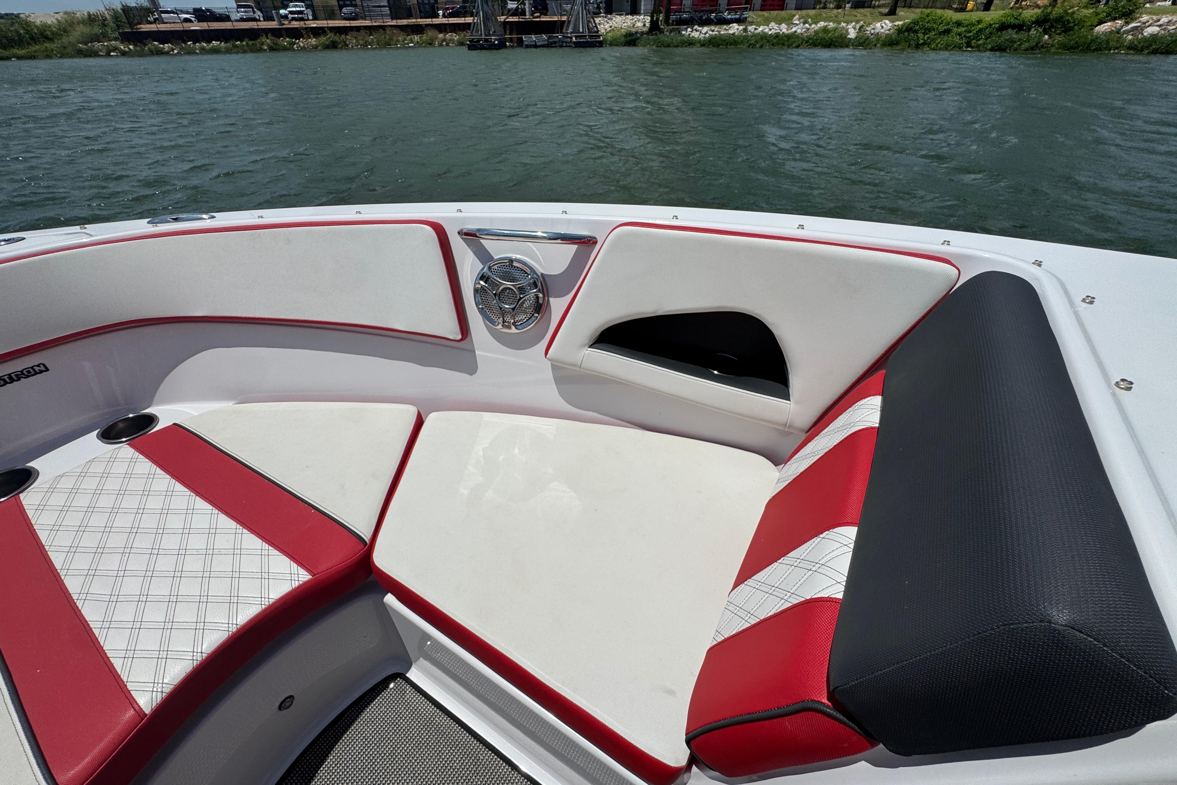 2017 Glastron GT 225 boat interior with red and white seating by the water.
