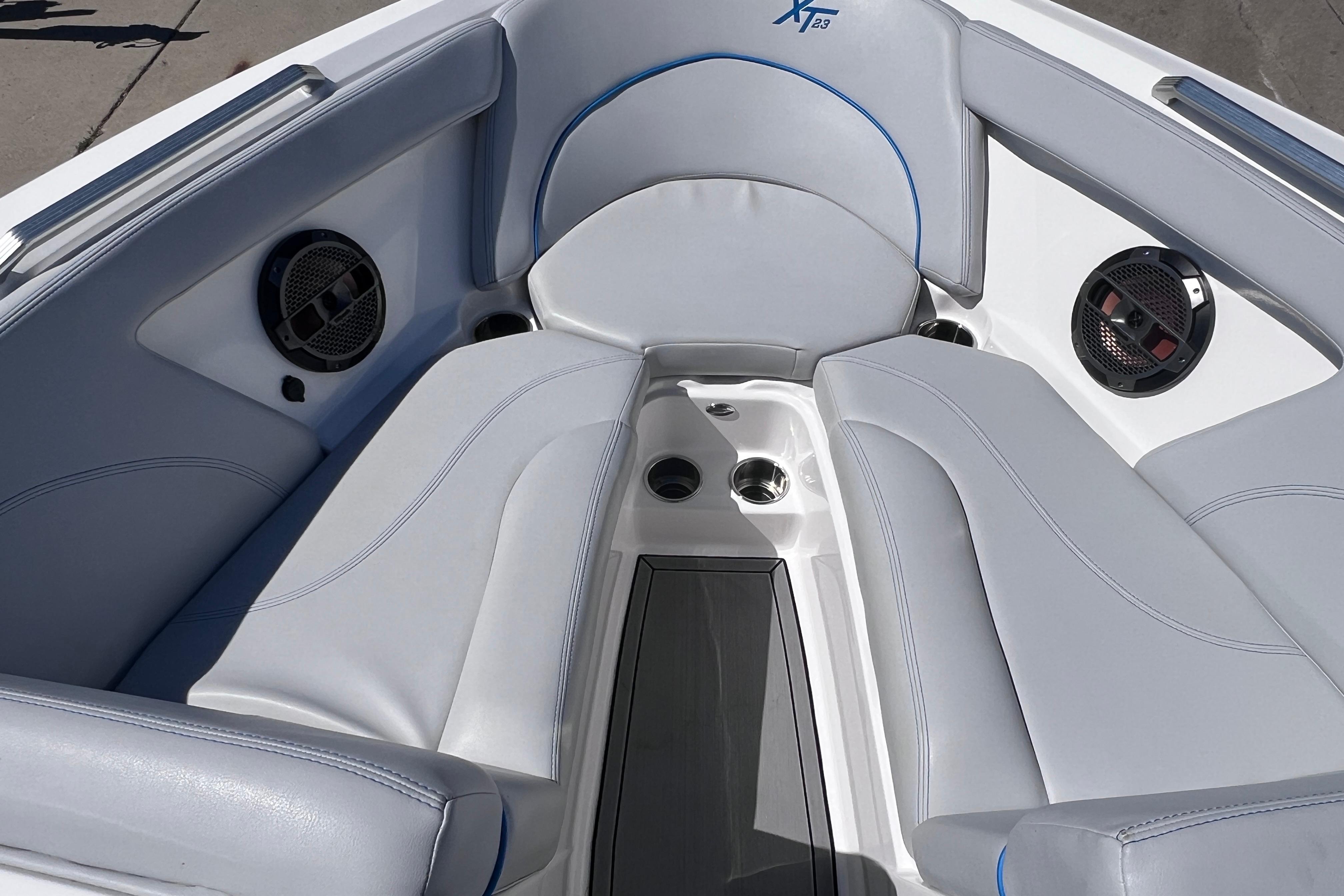 Interior of 2021 MasterCraft XT23 boat with gray seating and built-in speakers.