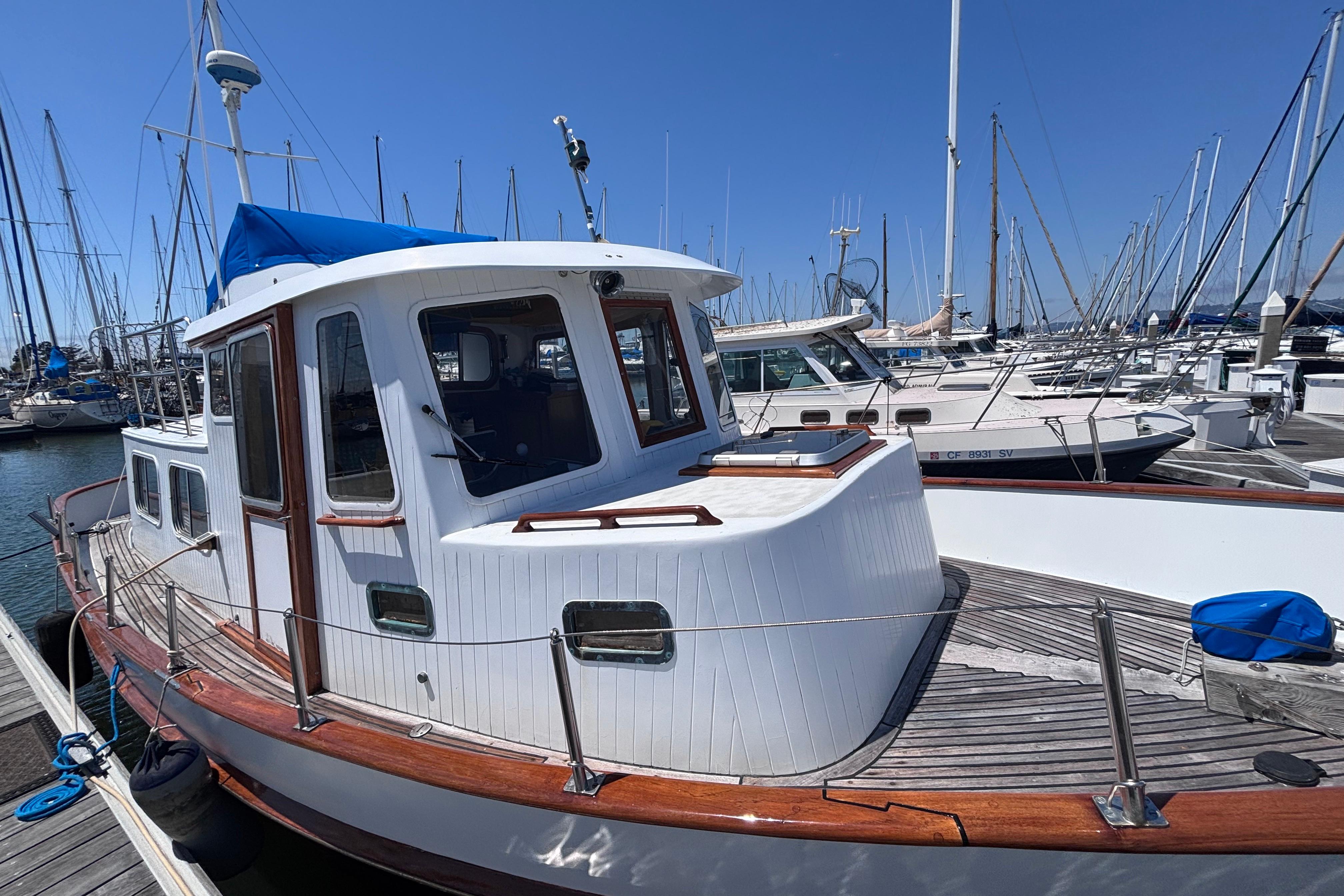 1985 Transpacific Marine Pacific Eagle 32 docked at marina, showcasing classic design and wooden accents.