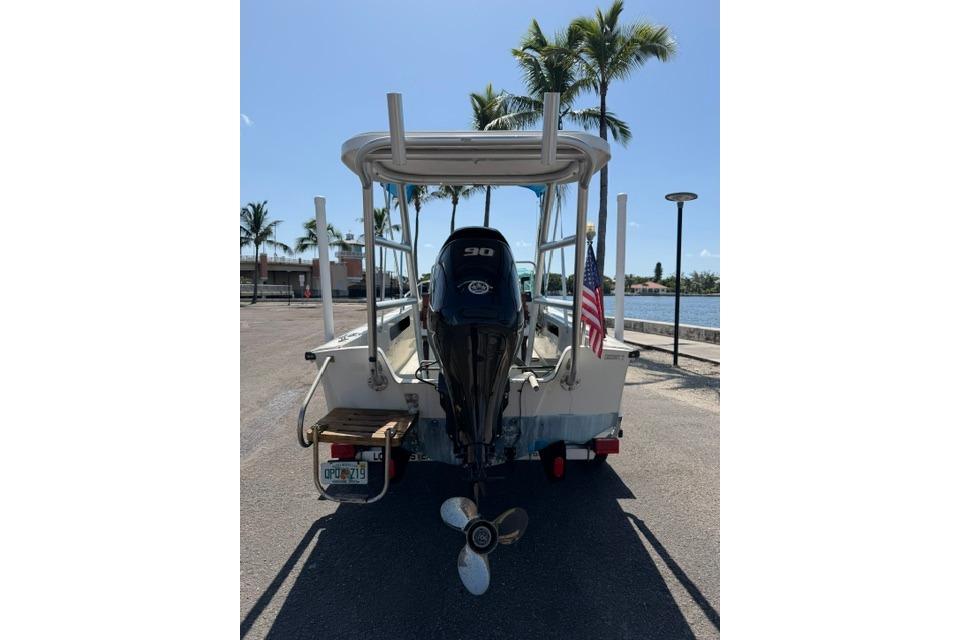 1990 Boston Whaler 17 Newport boat with outboard motor, parked near waterfront.