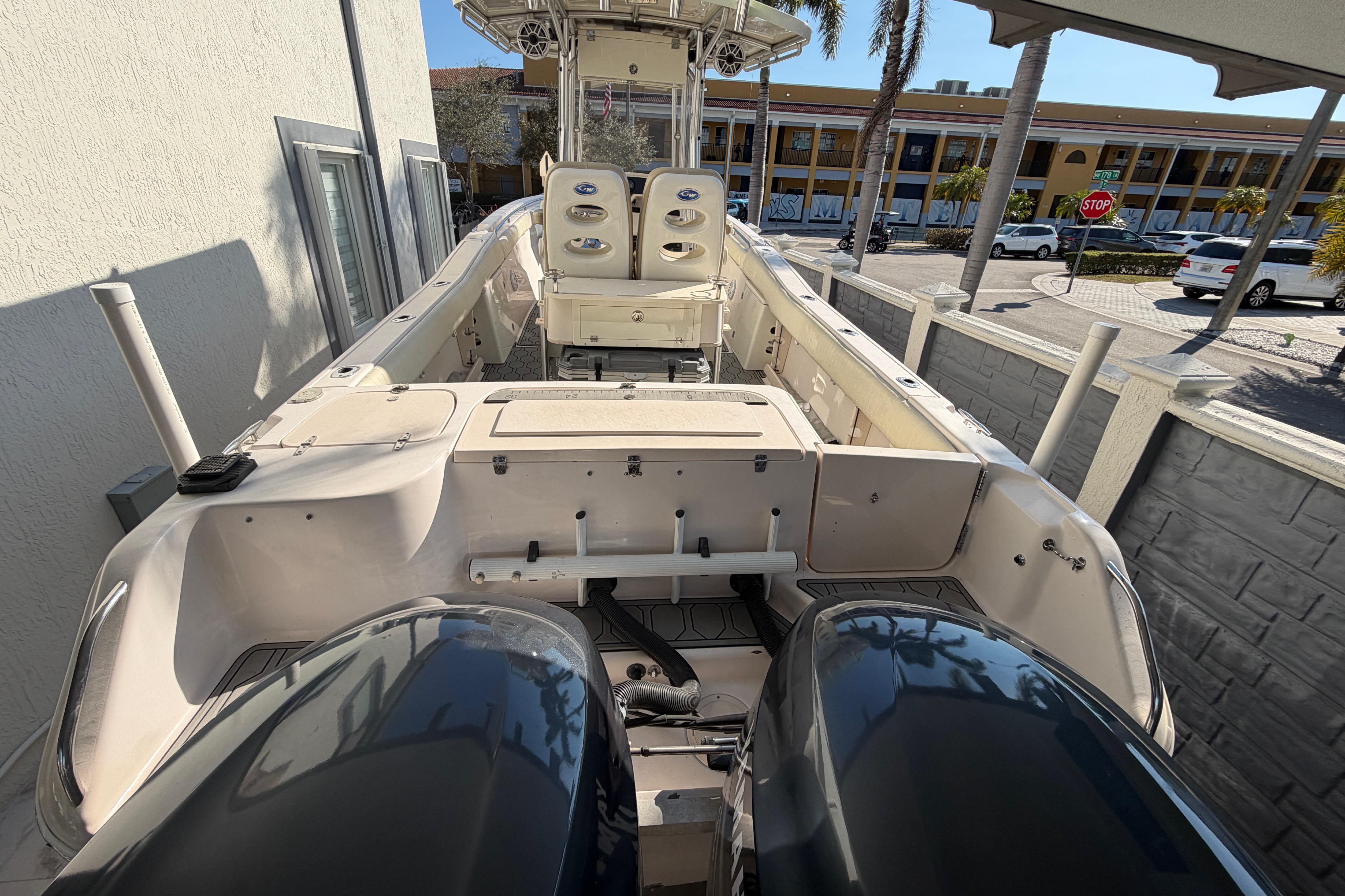 2004 Grady White 273 boat with dual engines, docked near a building.