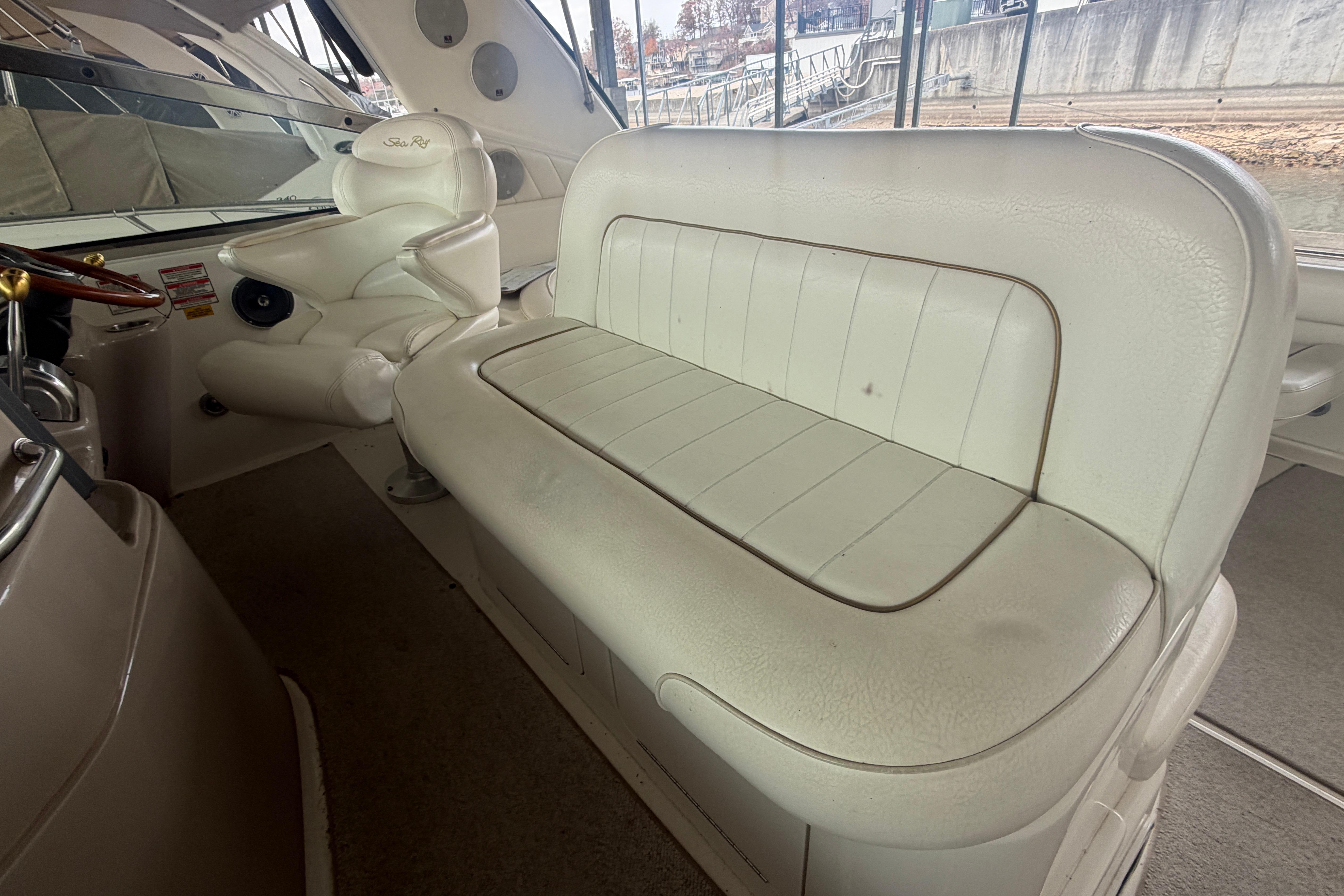 1999 Sea Ray 400 Sundancer interior with white leather seating and helm chair.