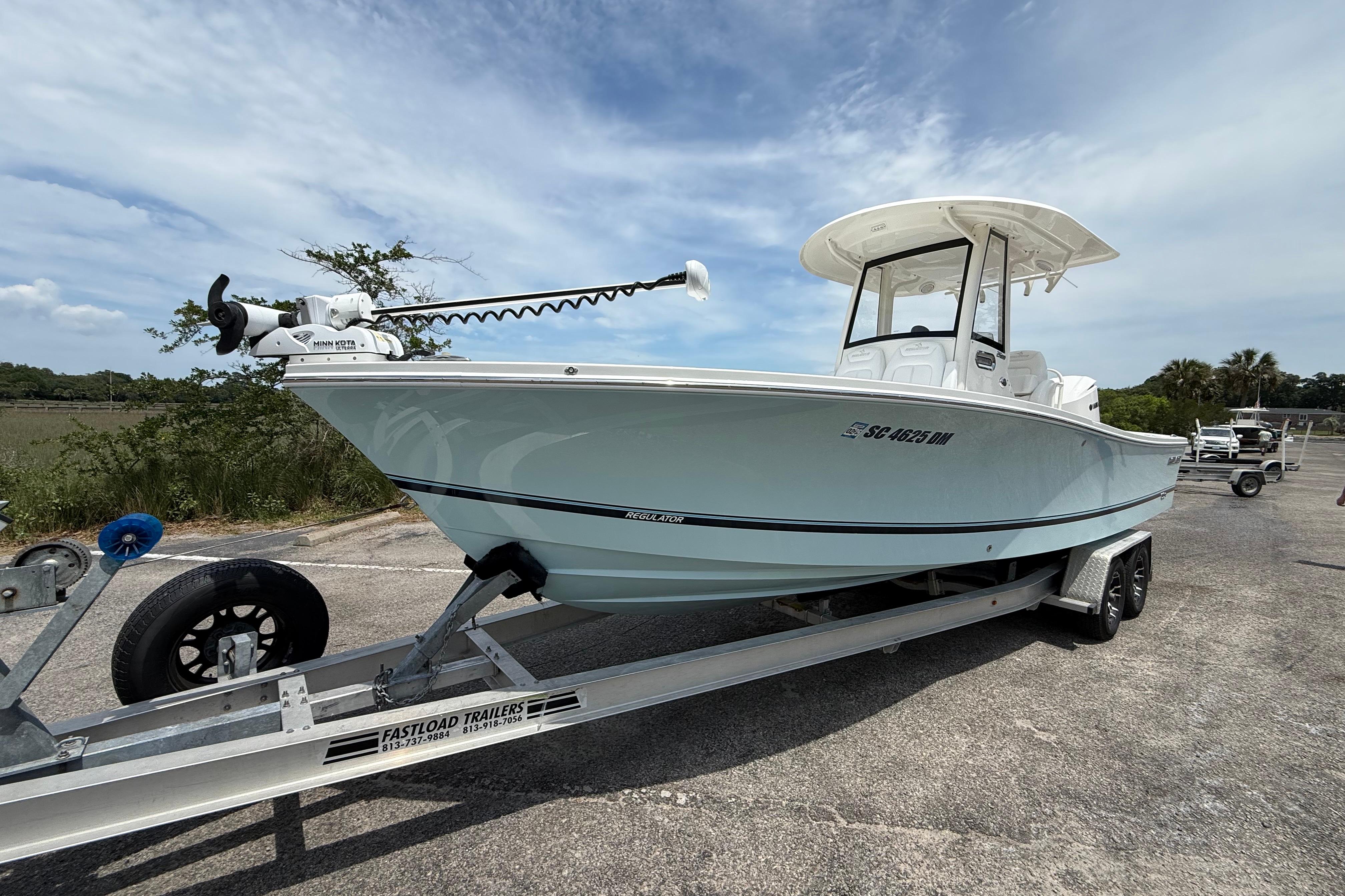2019 Regulator 26XO boat on trailer, parked outdoors under a cloudy sky.