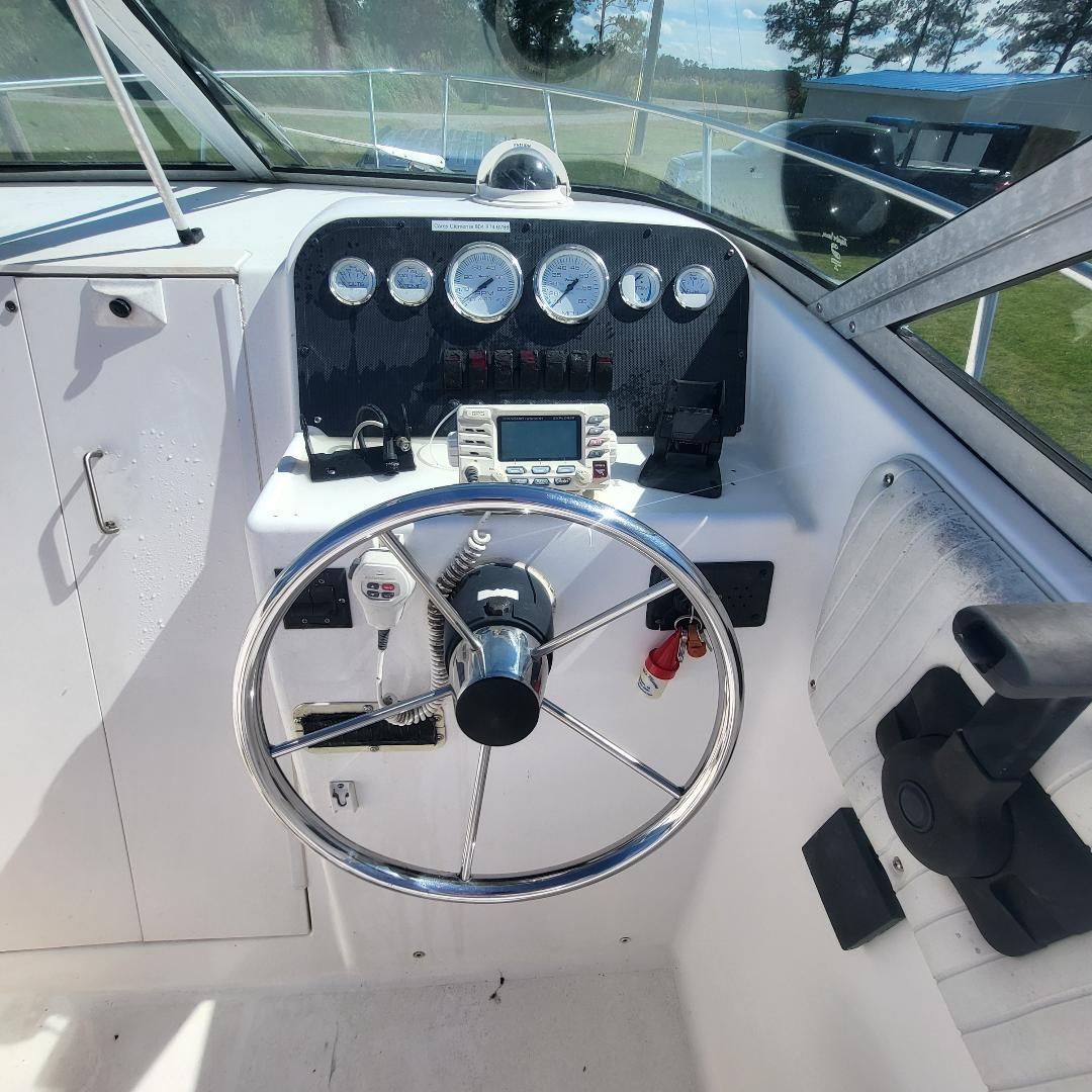 Dashboard of a 1998 Sport-Craft 211WAC boat with steering wheel and instruments.