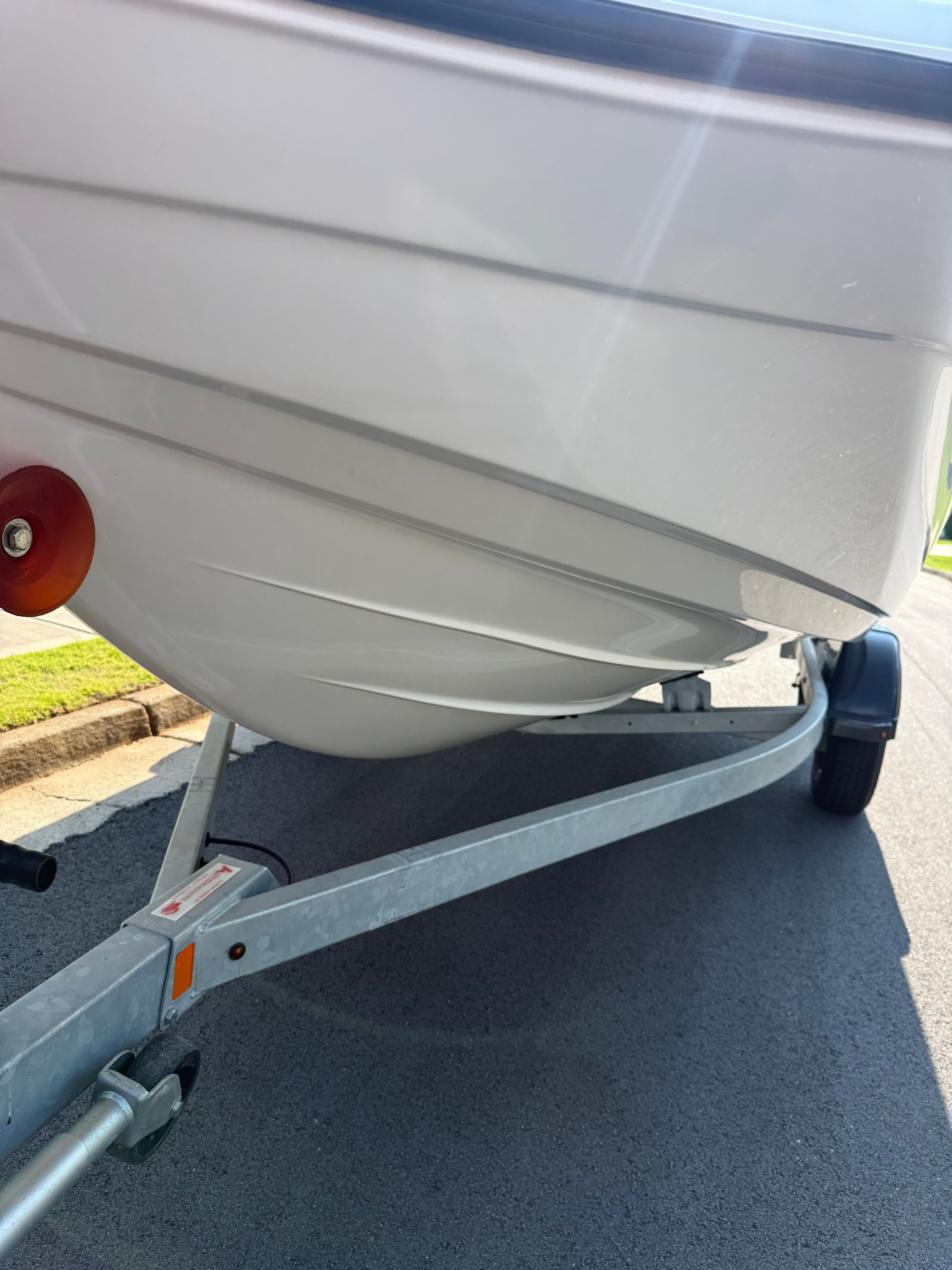 Close-up of a white boat's hull on a trailer.