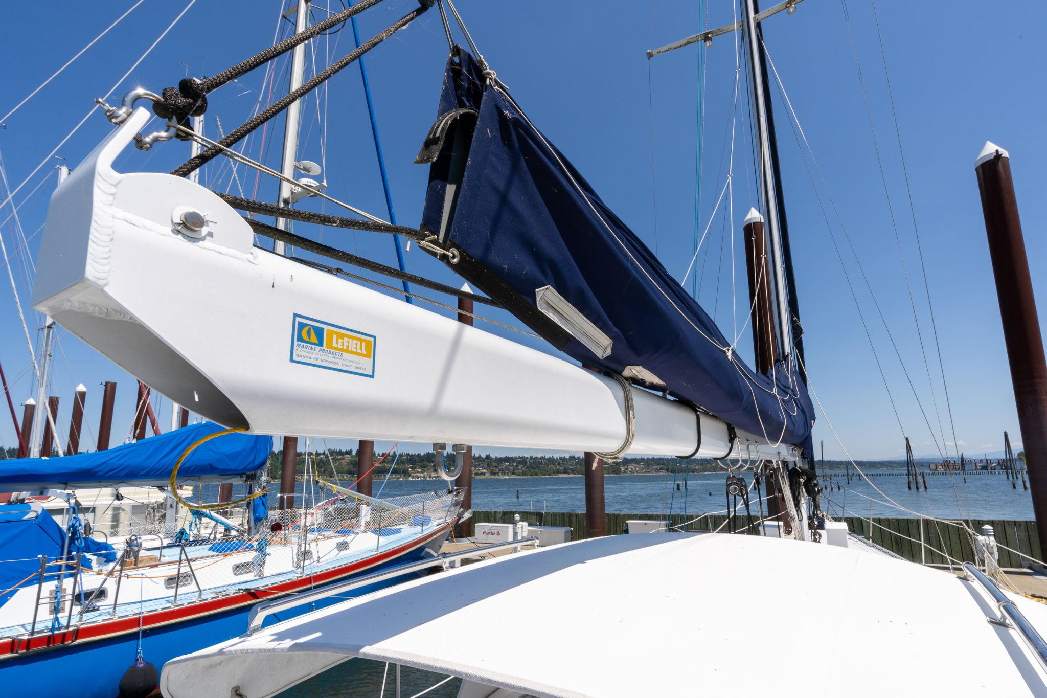 1978 Cascade High Side sailboat with blue sail cover docked at marina.