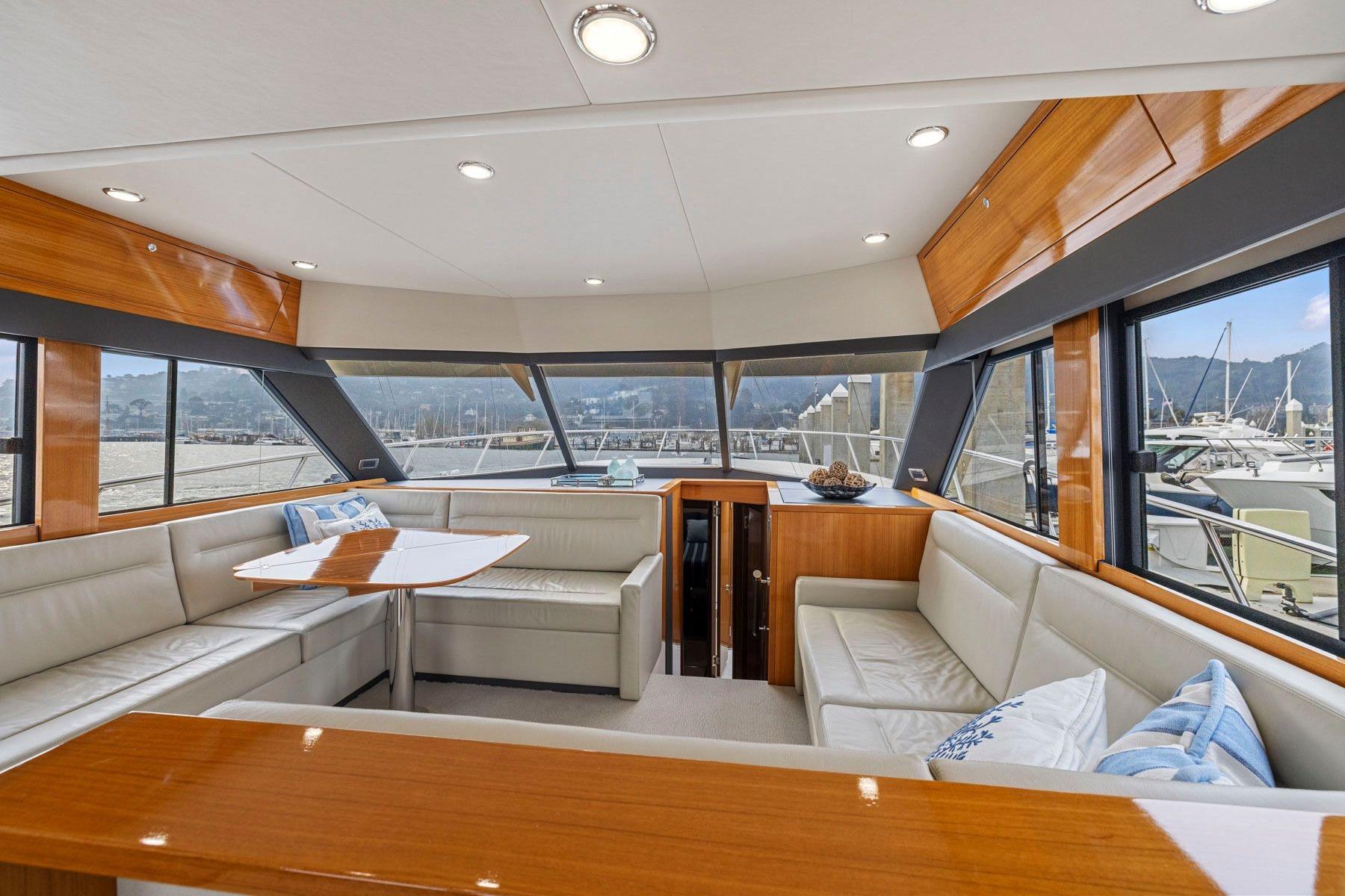 Luxurious interior of 2014 Maritimo M50 yacht with elegant seating and panoramic windows.