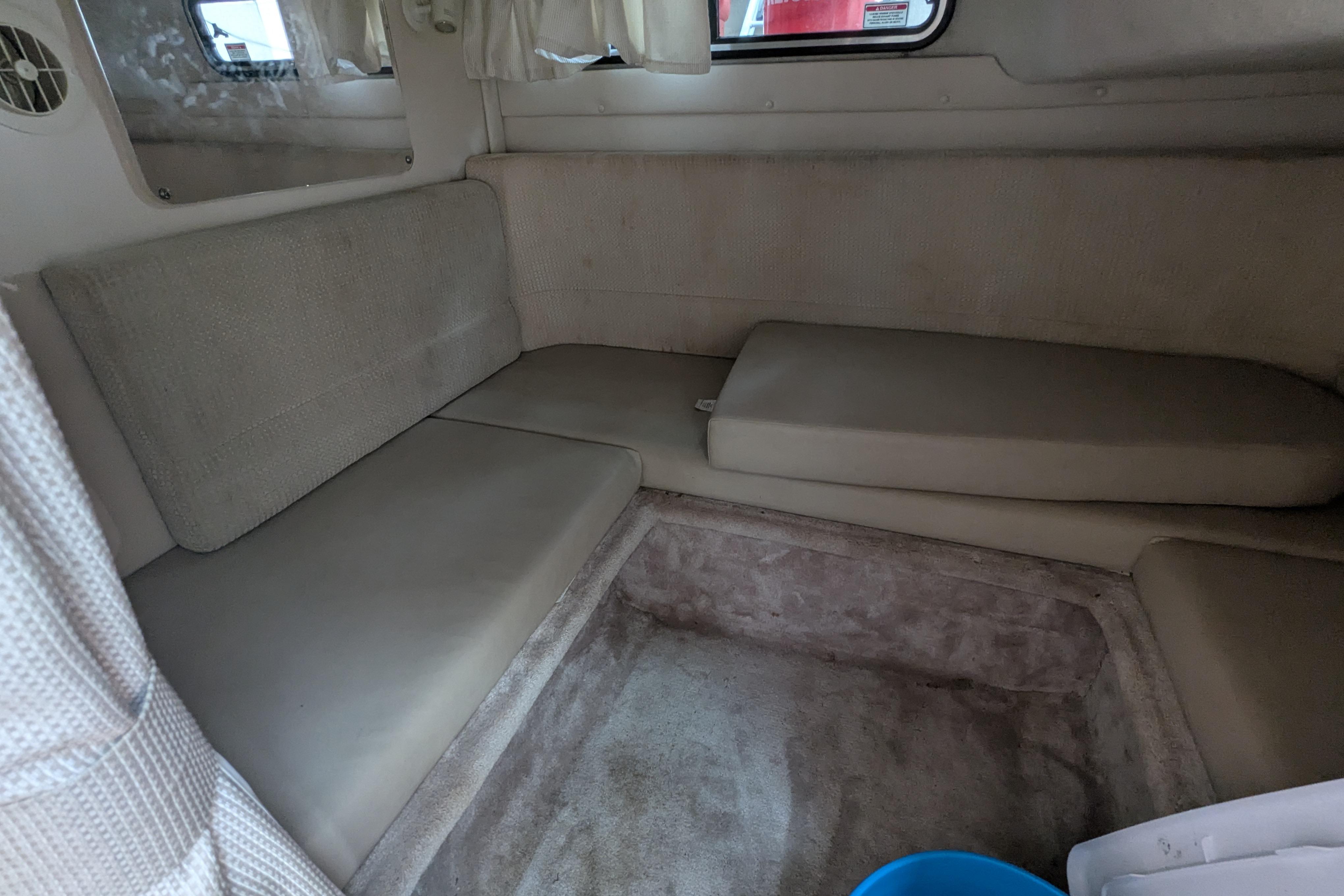 Interior cabin of a 2003 Monterey 282 Cruiser with beige seating and curtains.