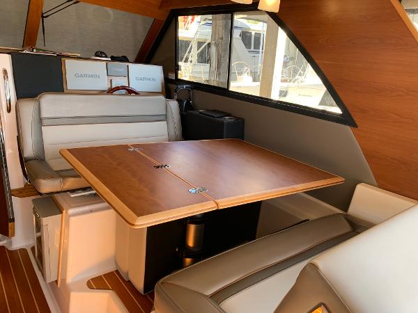 2021 Cutwater C-32 CB interior with dining table and seating, featuring Garmin equipment.
