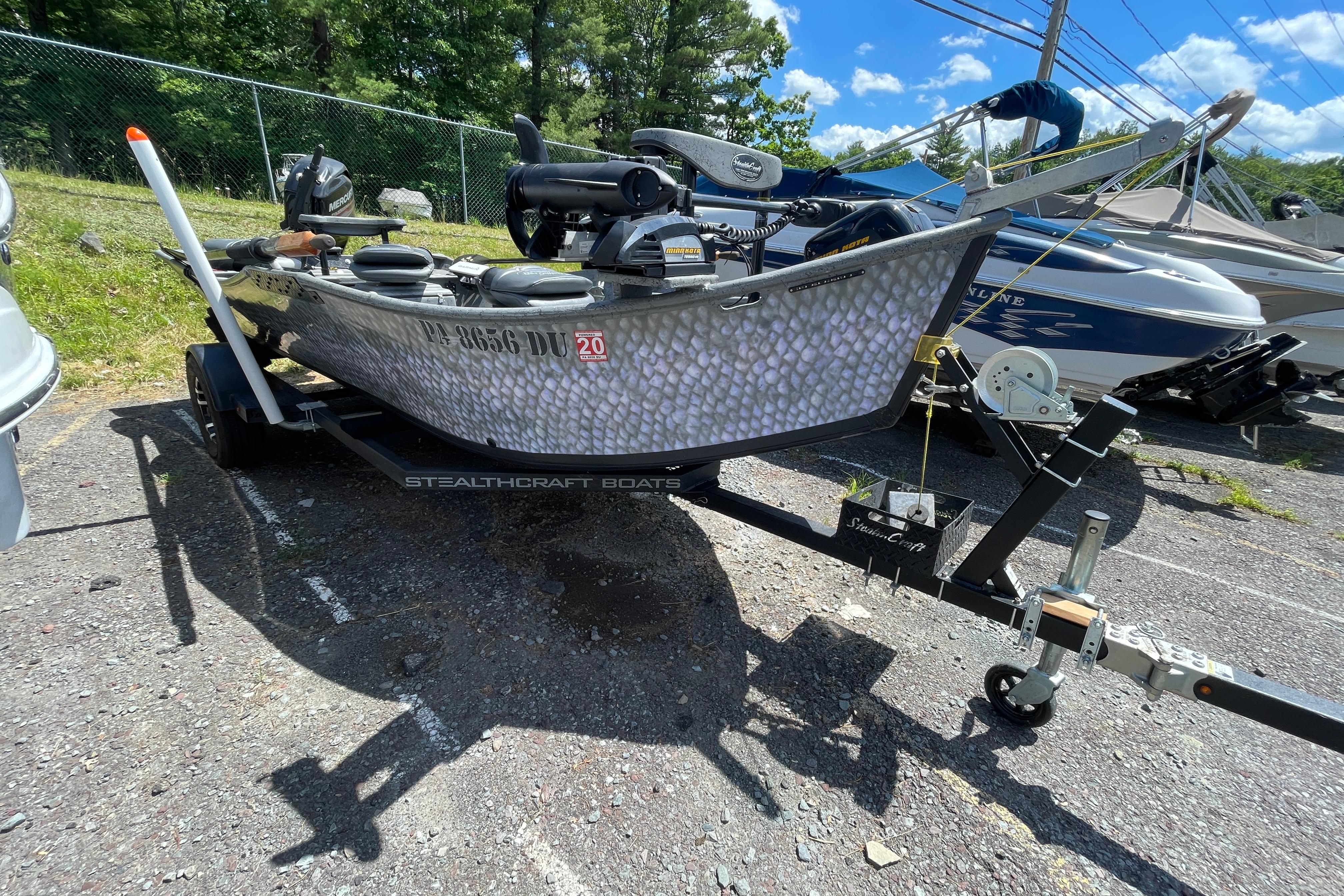 2018 StealthCraft 16 Power Drifter boat on trailer, parked outdoors under blue sky.