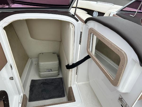 2010 Cobalt 262 boat interior with compact toilet and storage area.