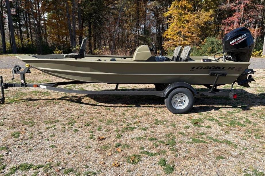 2026 Tracker Grizzly 1754 SC boat on trailer, parked outdoors with autumn foliage.