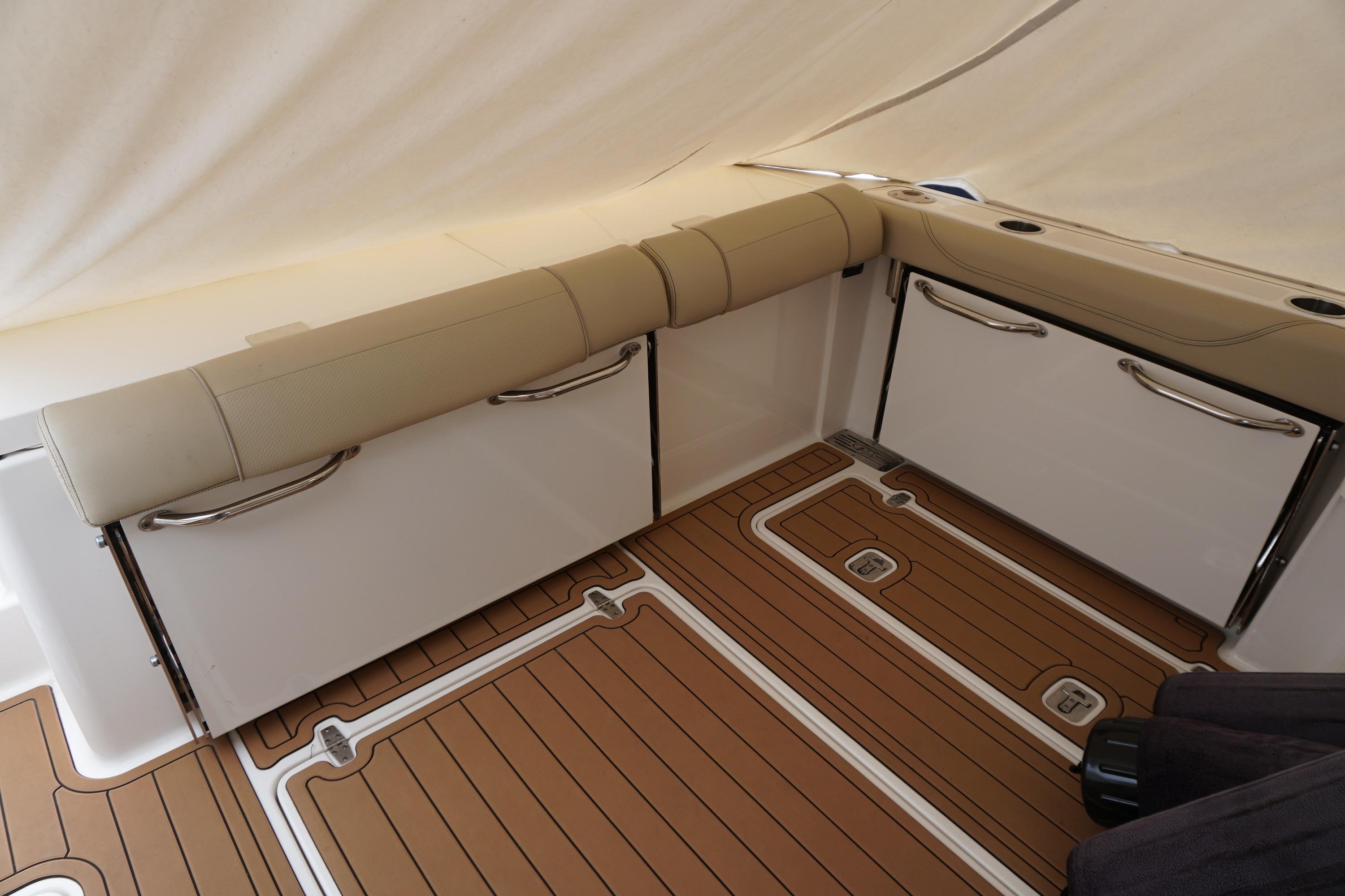 2021 Pursuit OS 325 Offshore boat interior with cushioned seating and teak flooring.