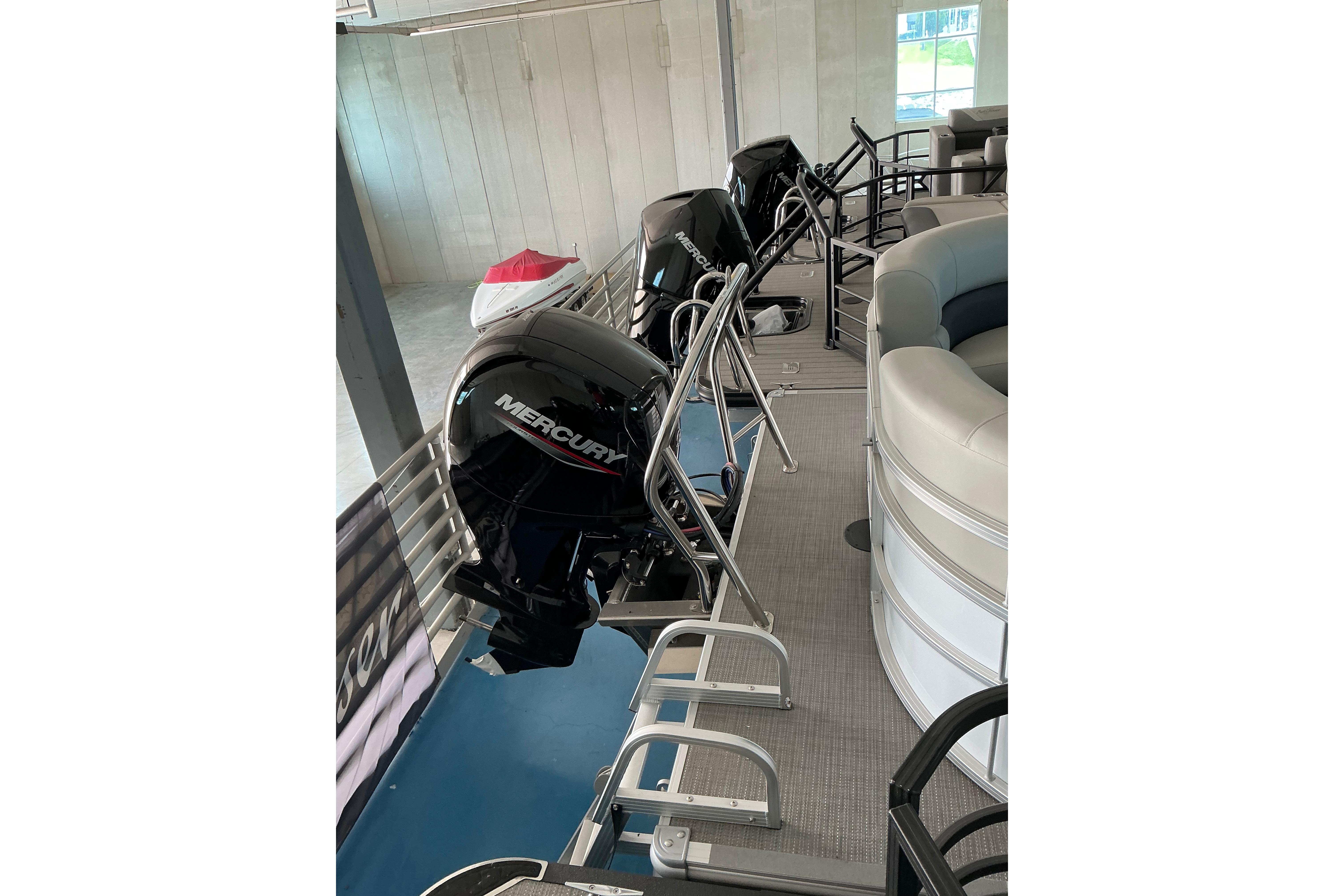 2024 SunChaser Vista 22 LR pontoon boat with Mercury outboard motor in showroom.