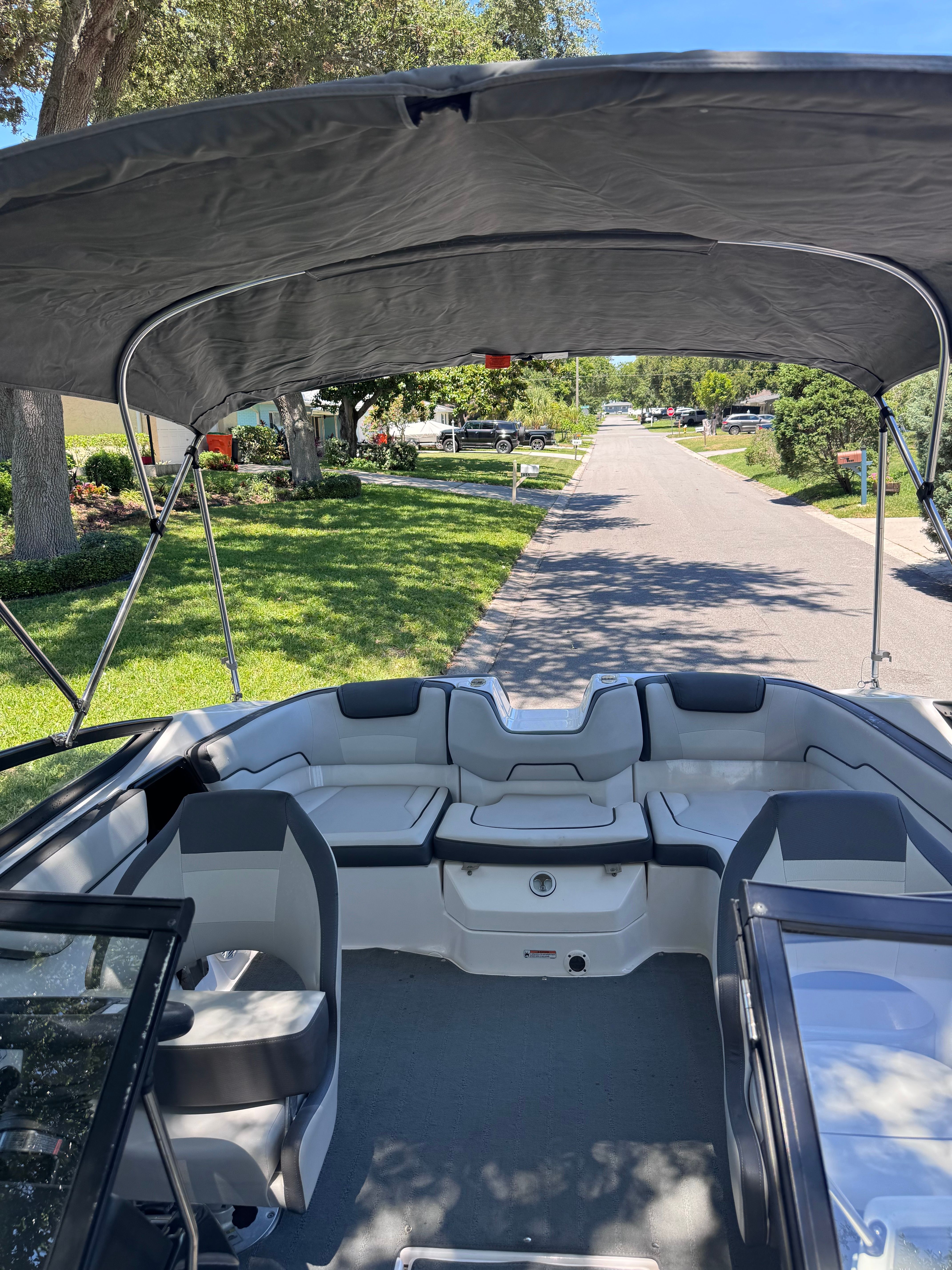 2020 Yamaha SX190 boat with Bimini top parked on a street.