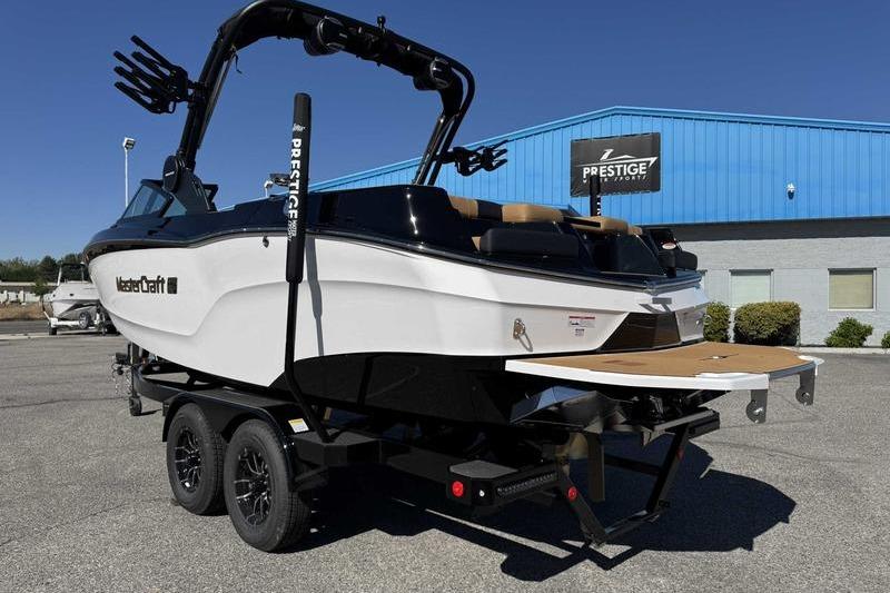 2026 MasterCraft XT22 boat on trailer at dealership, showcasing sleek design and modern features.