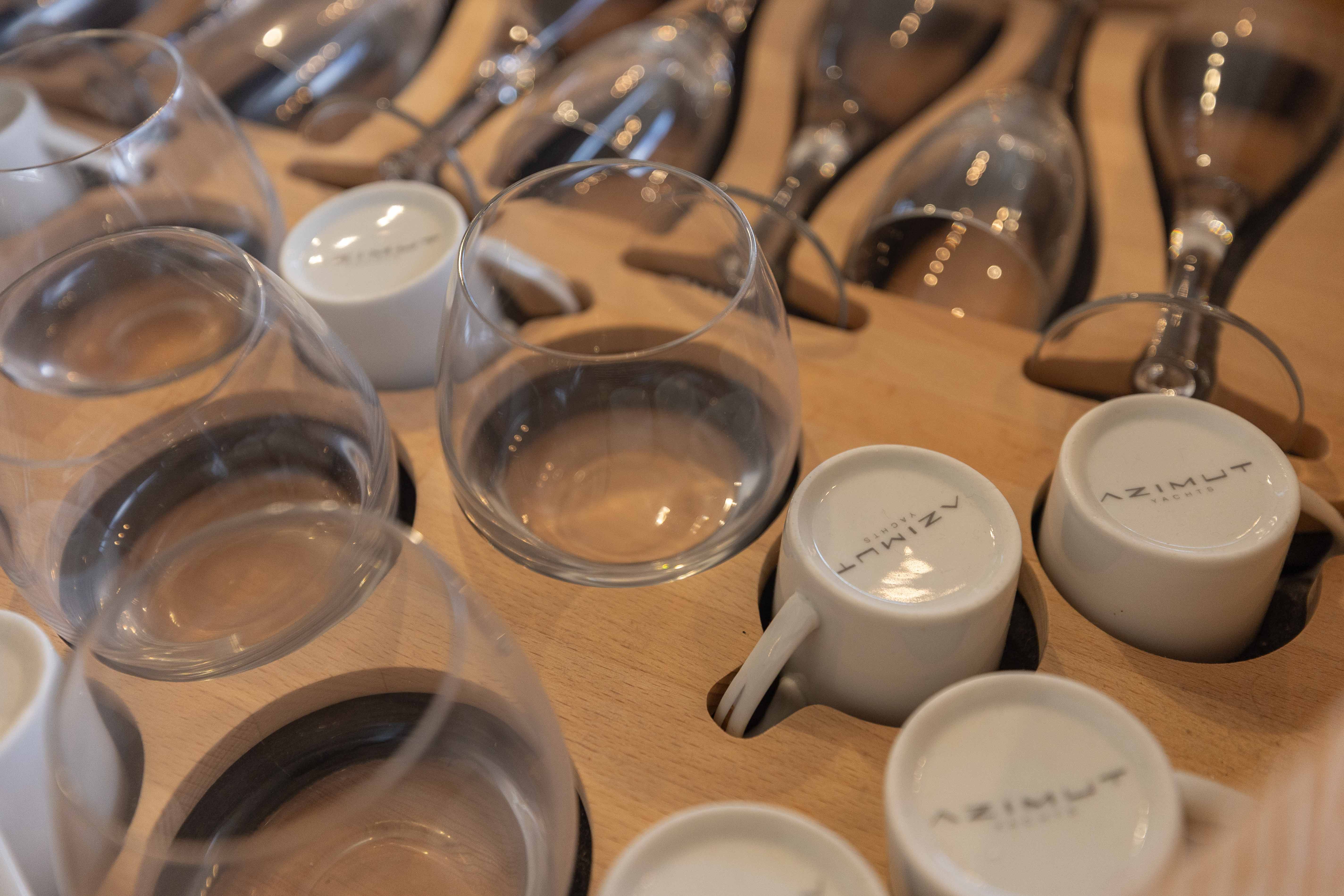 Wine glasses and Azimut-branded cups on a wooden rack, Azimut 60 Flybridge 2014.