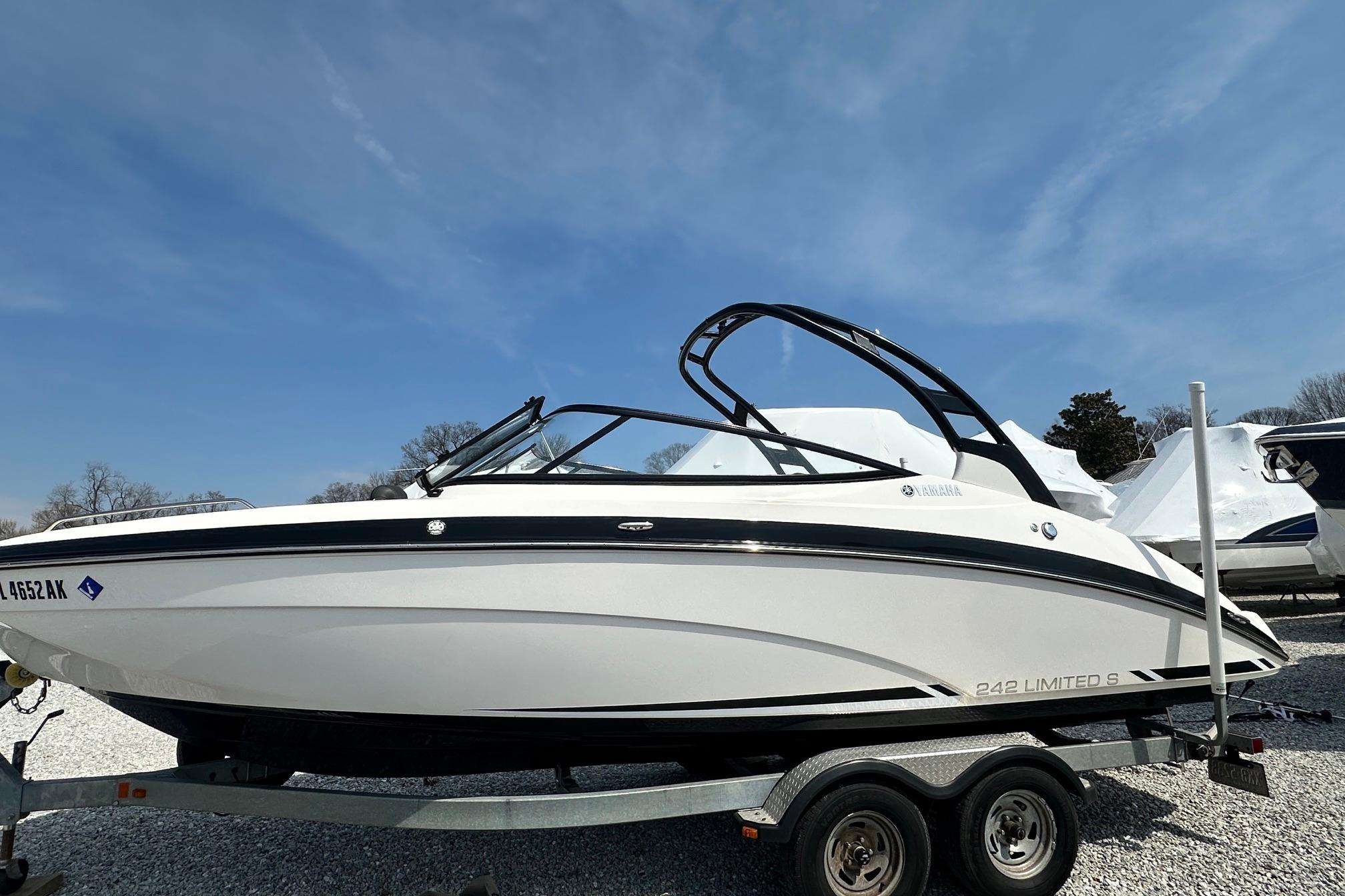 2016 Yamaha 242 Limited S boat on trailer under clear blue sky.