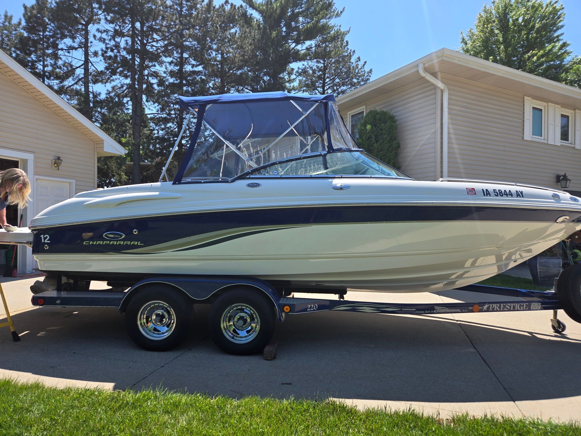 A 2005 Chaparral 220 SSi boat on a trailer in a driveway.
