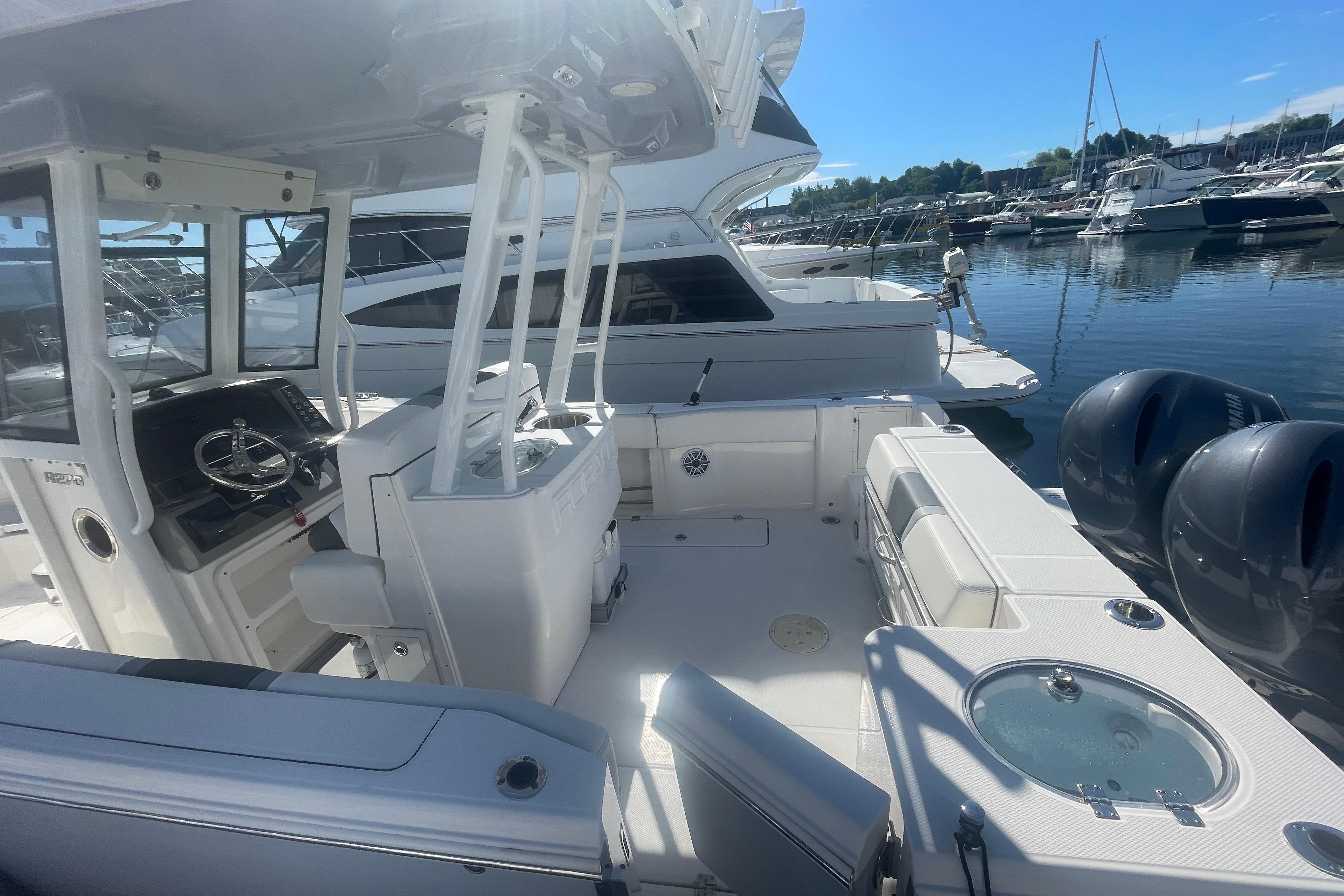 2023 Robalo R270 Center Console boat interior at marina, featuring dual engines.