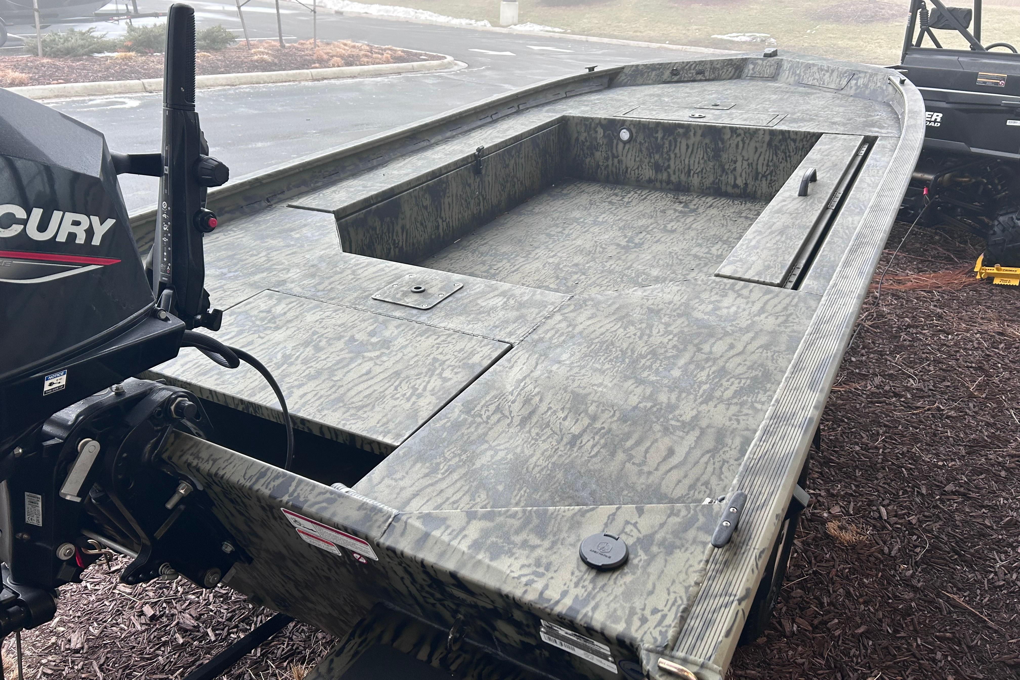 2026 Tracker Grizzly 1654 T Sportsman boat with camouflage design and Mercury outboard motor.
