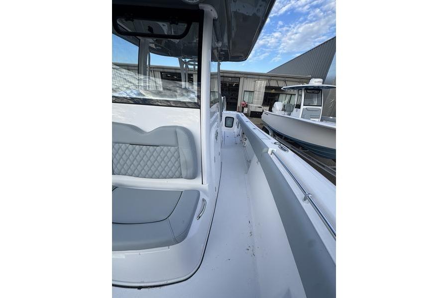 2026 Sportsman Open 282 Center Console boat, sleek design, docked near a warehouse.