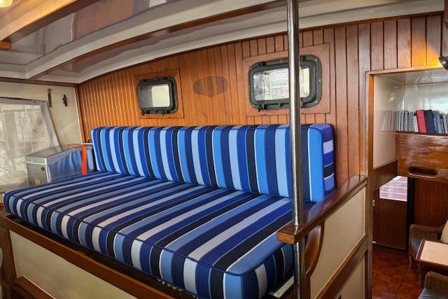 Interior of 1986 Krogen 42 Classic yacht with striped blue seating and wooden paneling.