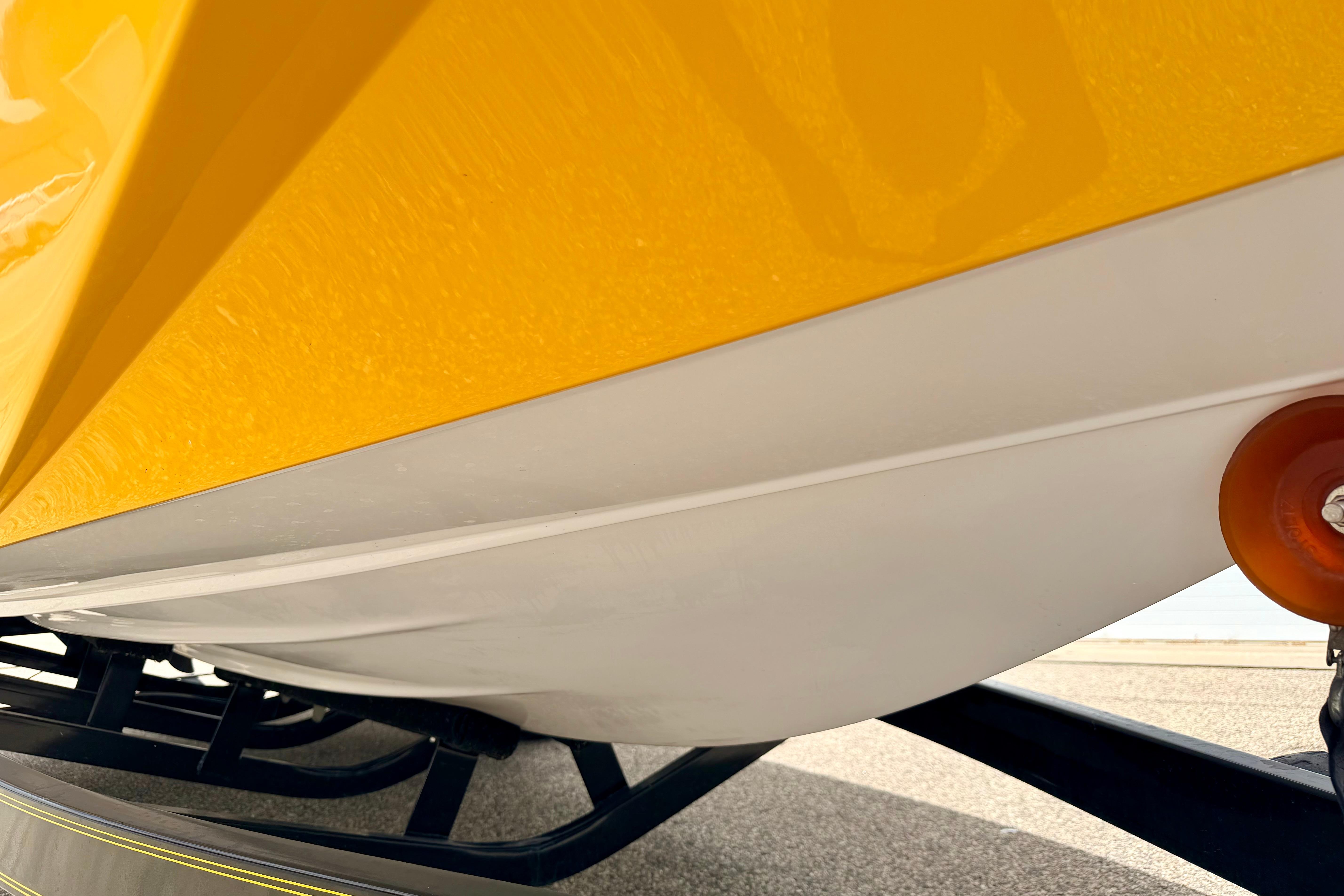 Close-up of a 2014 Tigé R20 boat hull in yellow and white on a trailer.