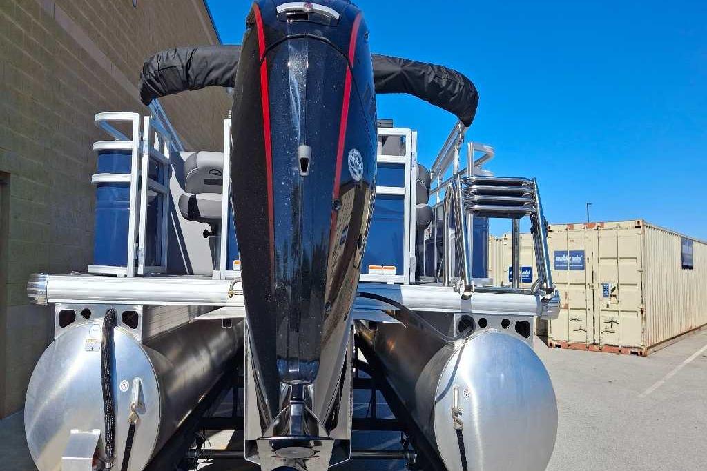 2026 Sun Tracker SportFish 20 DLX pontoon boat with powerful outboard motor, docked outdoors.