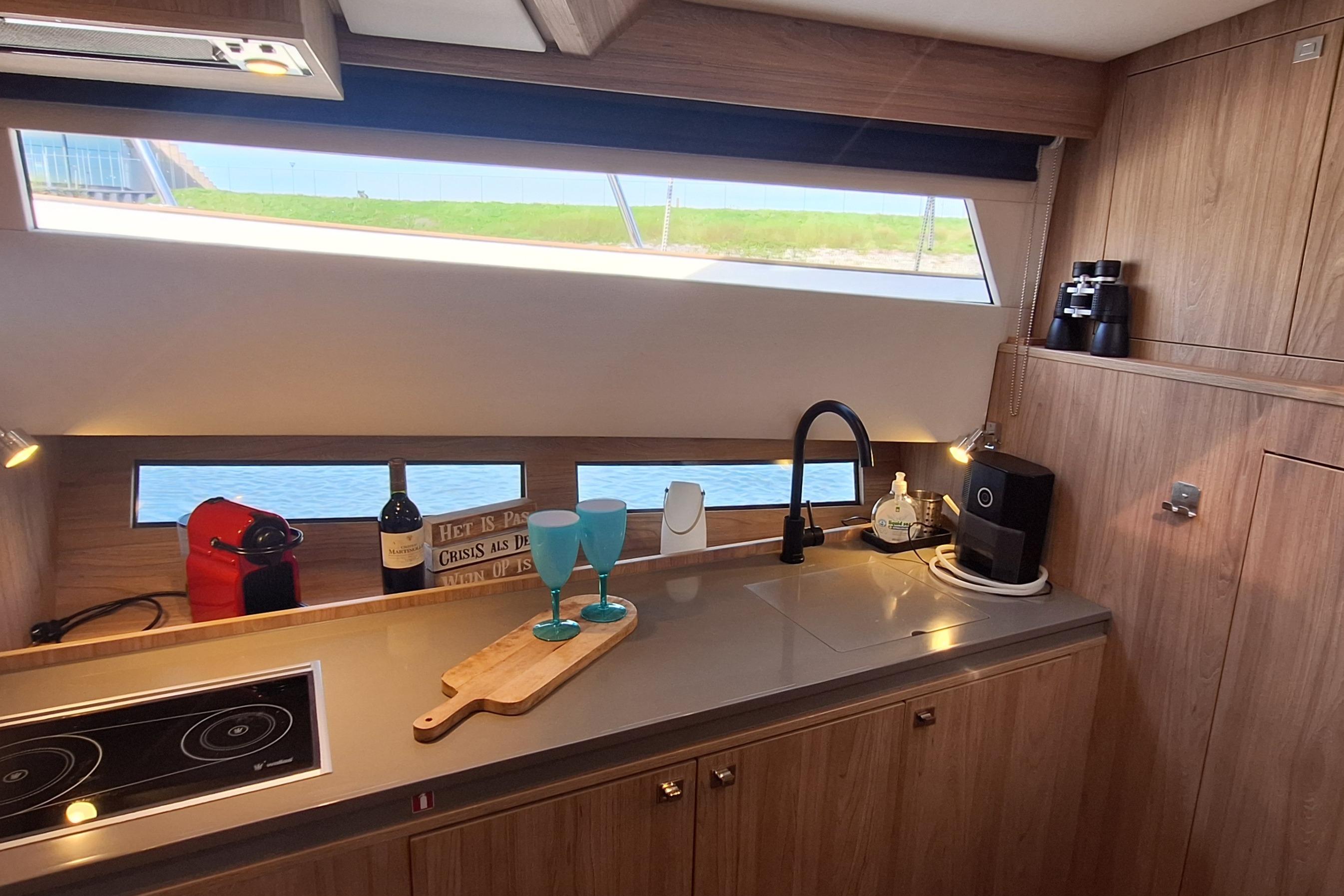 Modern kitchen interior of 2023 Antaris X yacht with appliances and scenic window view.