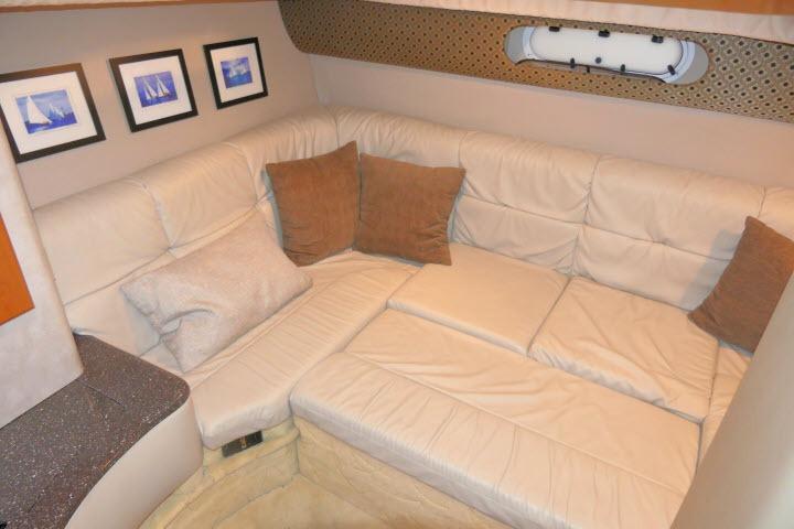 Interior of 2003 Thunderbird Formula 40PC yacht with beige leather seating and decorative pillows.