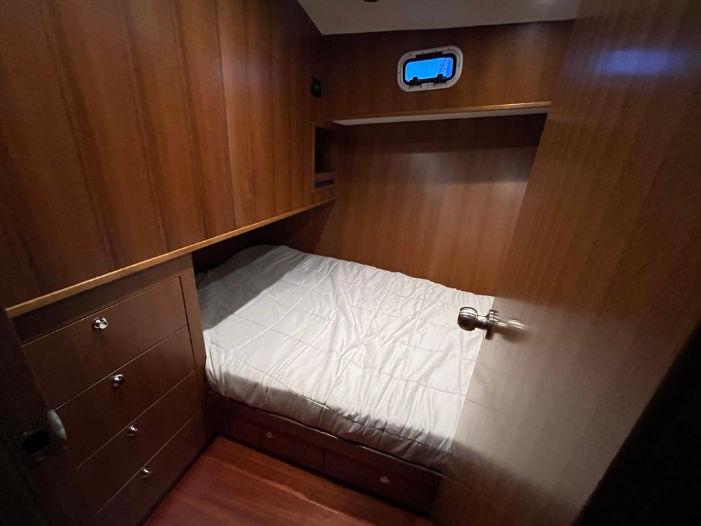 Cozy cabin interior of 2025 Bracewell 41 yacht with wooden paneling and bed.