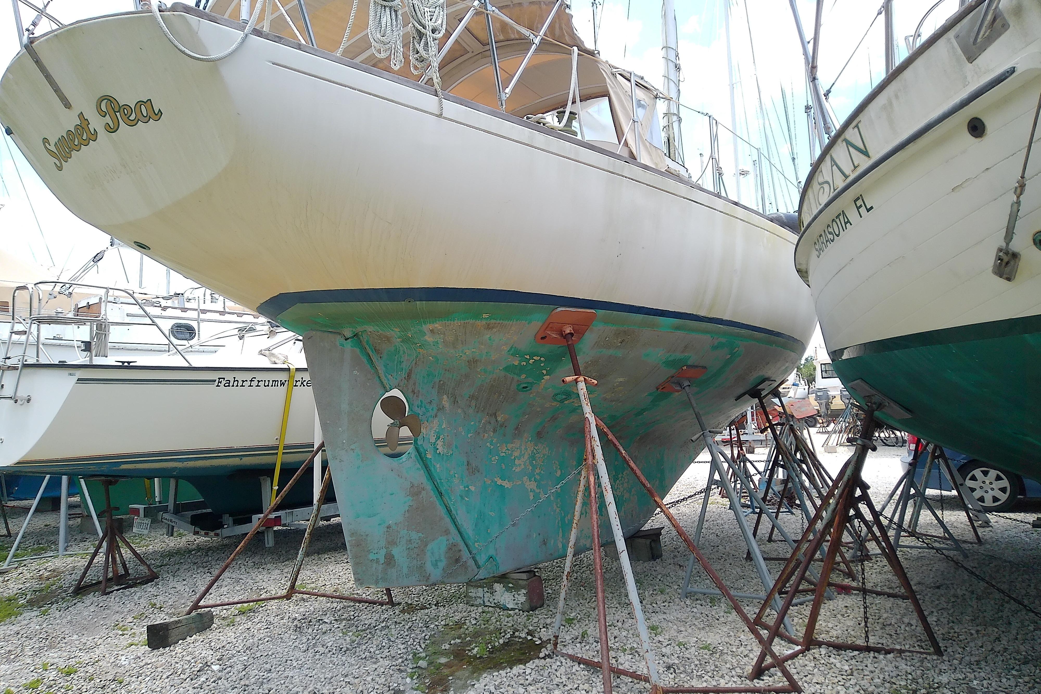1981 Sea Sprite 34 sailboat on stands, hull showing wear, in a boatyard setting.
