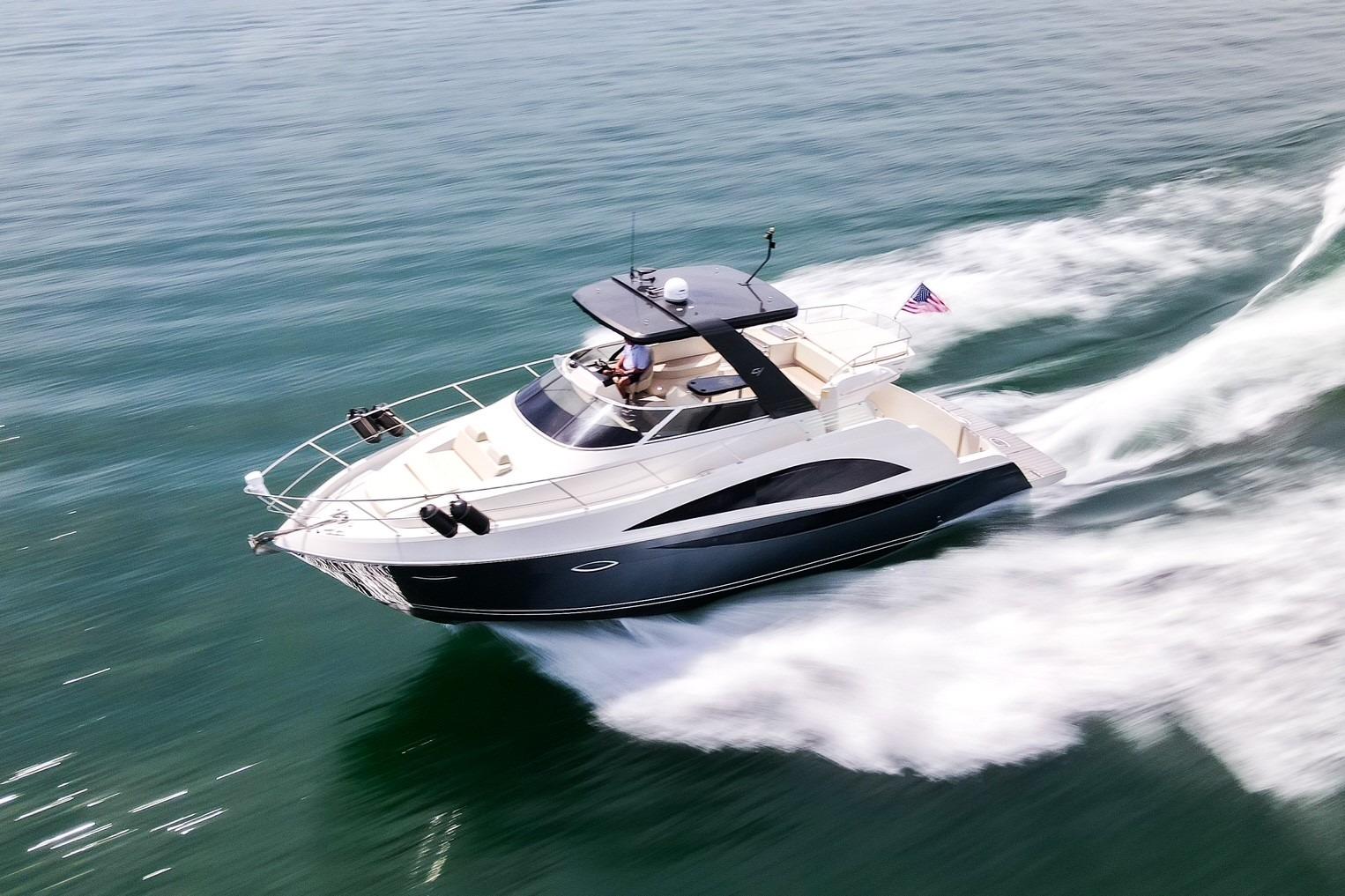 2011 Carver 44 Sojourn yacht cruising swiftly on open water.