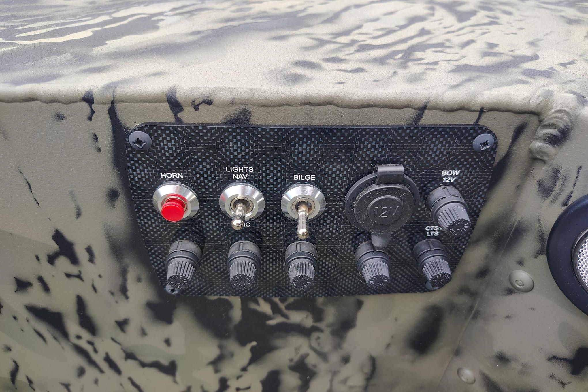 Control panel of 2026 Tracker Grizzly 1654 T Sportsman boat with switches and knobs.