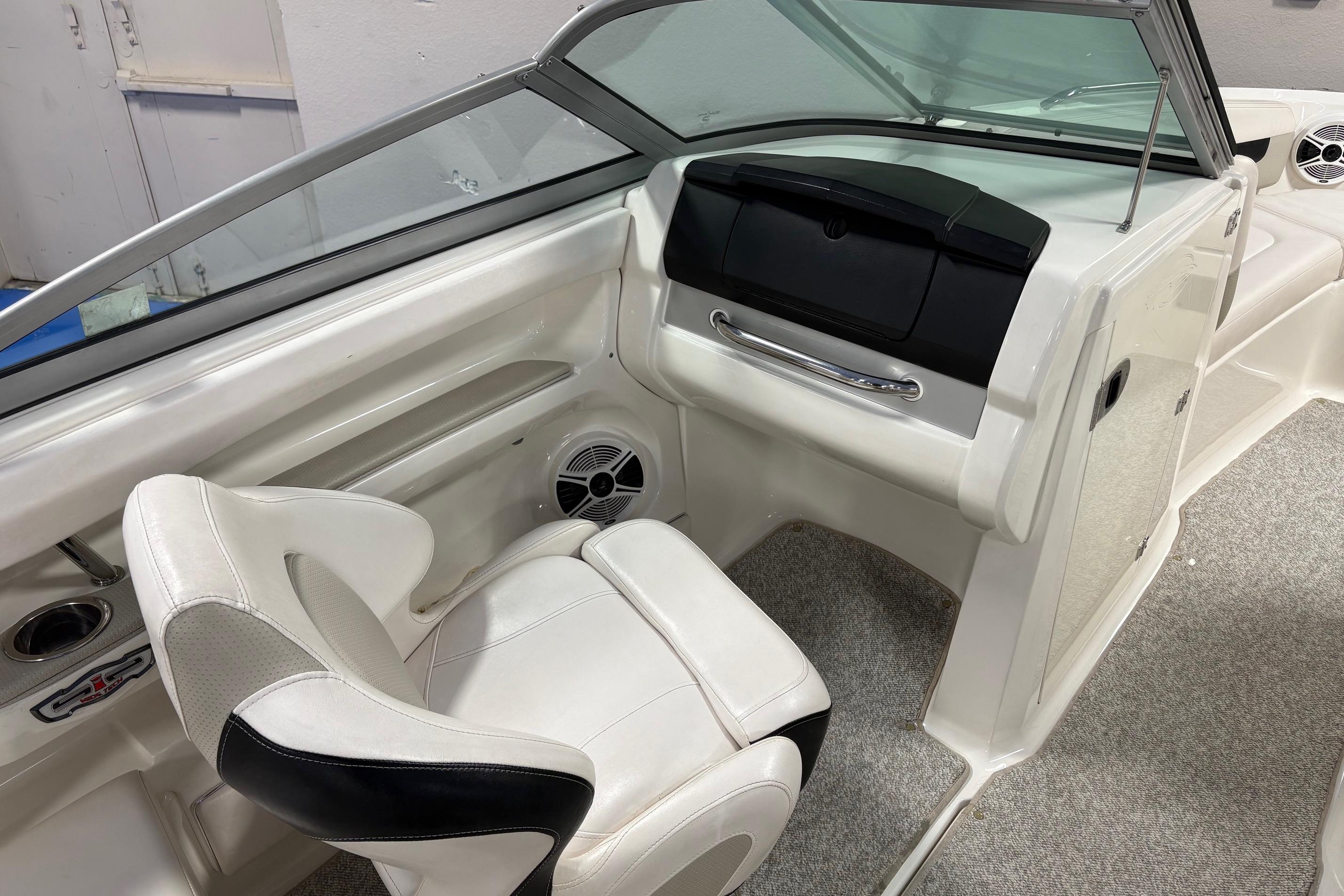 Interior of a 2011 Chaparral 216 SSi boat featuring white seating and dashboard.
