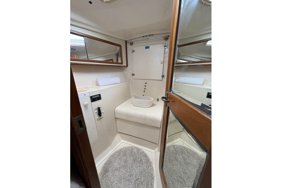 Interior of 2002 Saga 43 yacht bathroom with mirror and cushioned seat.