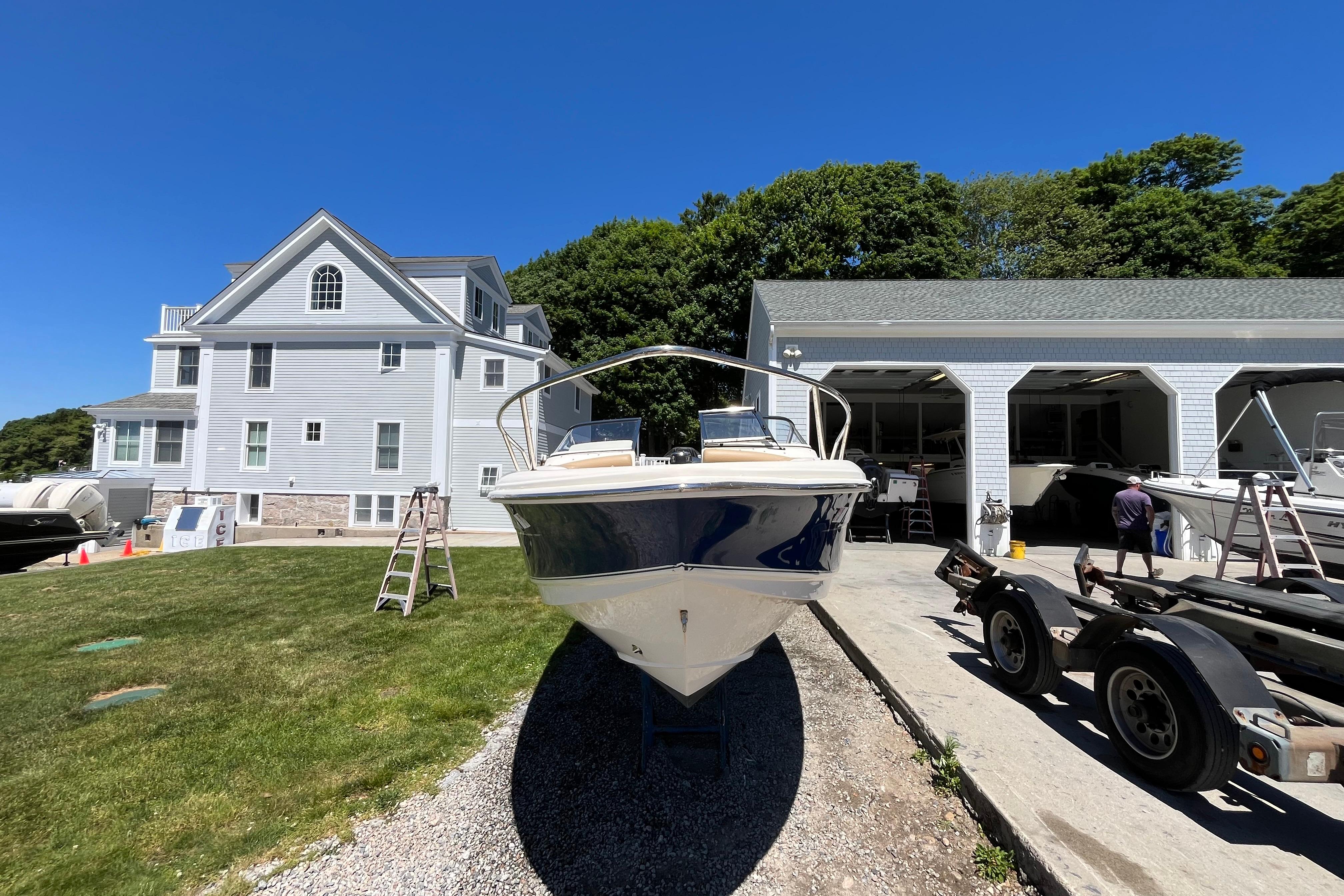 2017 Scout 210 Dorado boat parked near a house and garage on a sunny day.