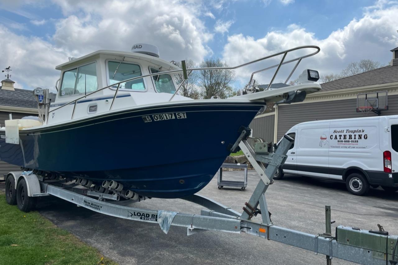 2012 Steiger Craft Miami boat on trailer, parked near catering van.