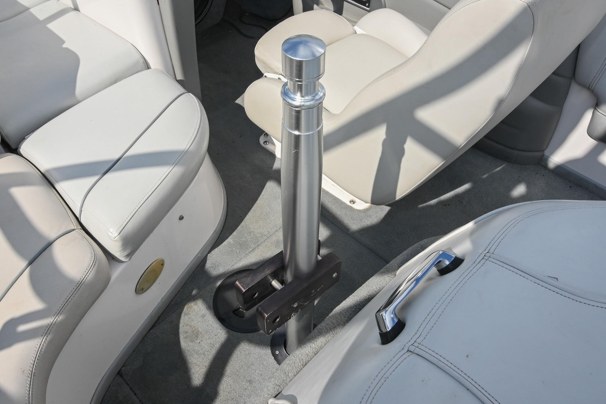 Interior of a 2004 Supra Launch SS boat with beige seating and a central metal pole.