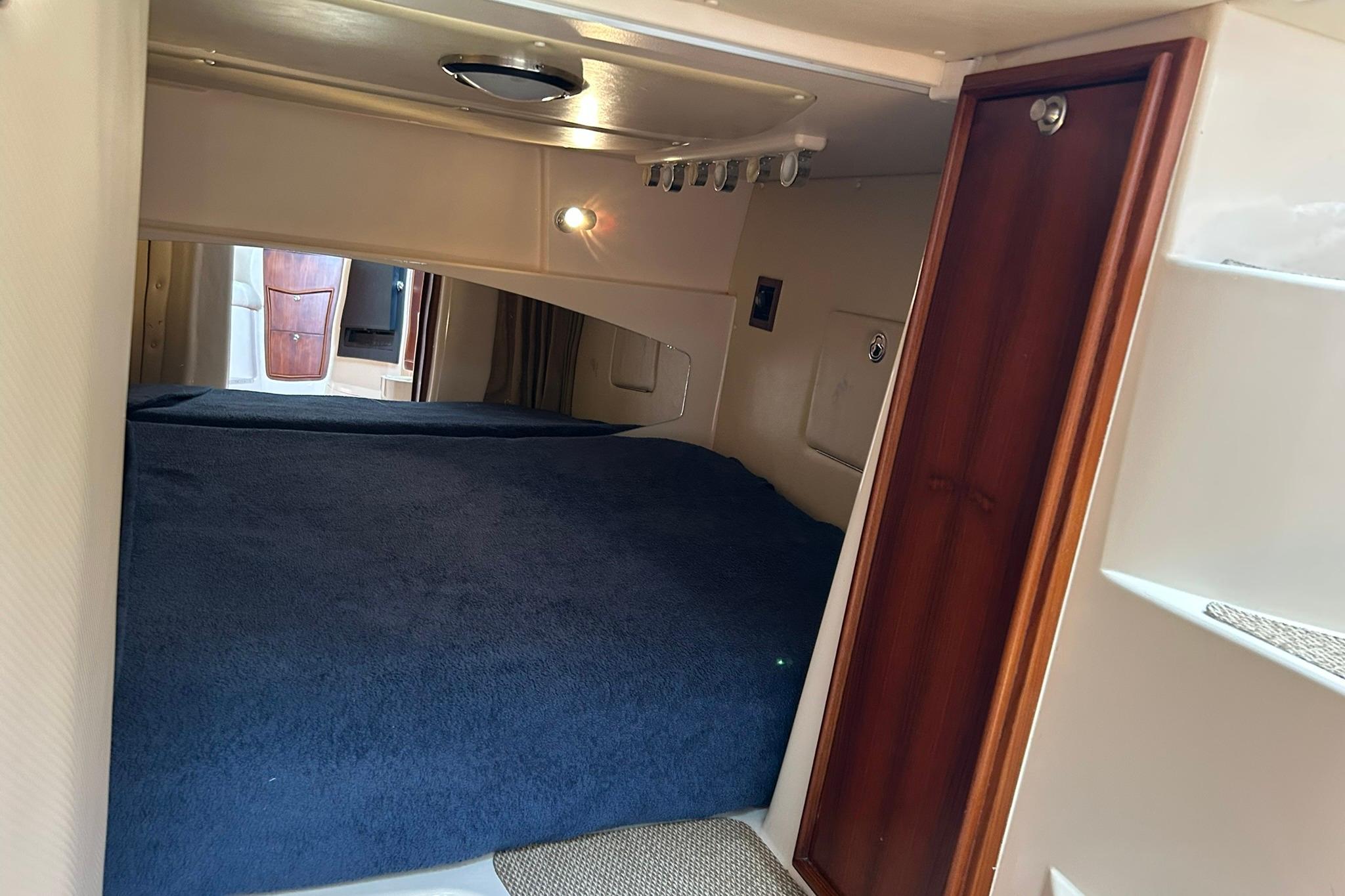 Interior cabin of 2007 Grady-White Express 360 with cozy bed and wooden accents.