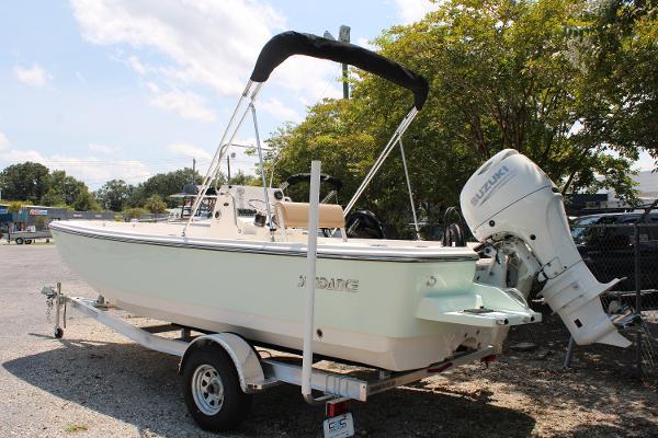 2023 Sundance DX20 boat on trailer with Suzuki outboard motor, parked outdoors.