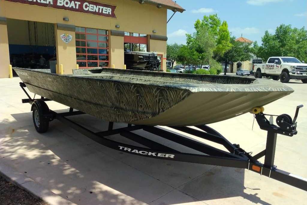 2025 Tracker Grizzly 2072 Utility boat on trailer at dealership, outdoors.