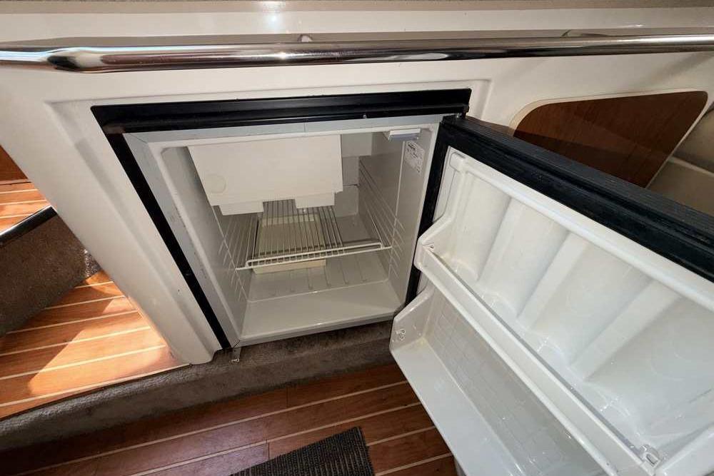 Open refrigerator inside 2001 Monterey 282 Cruiser boat, showcasing interior storage space.