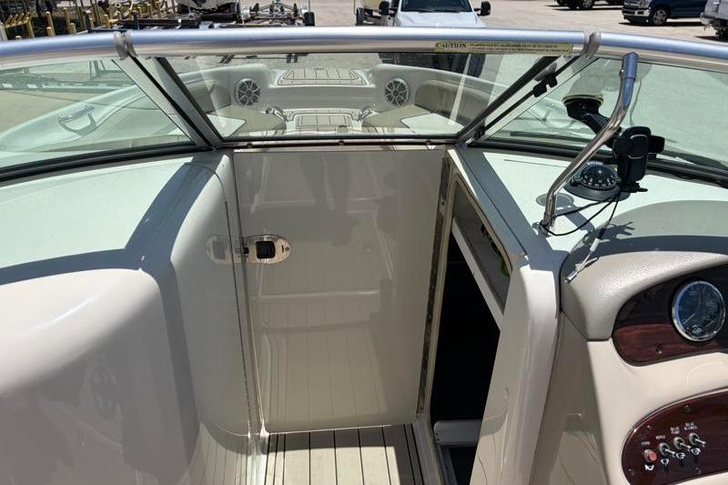 2007 Sea Ray 240 Sundeck interior view with open cabin door and dashboard controls.