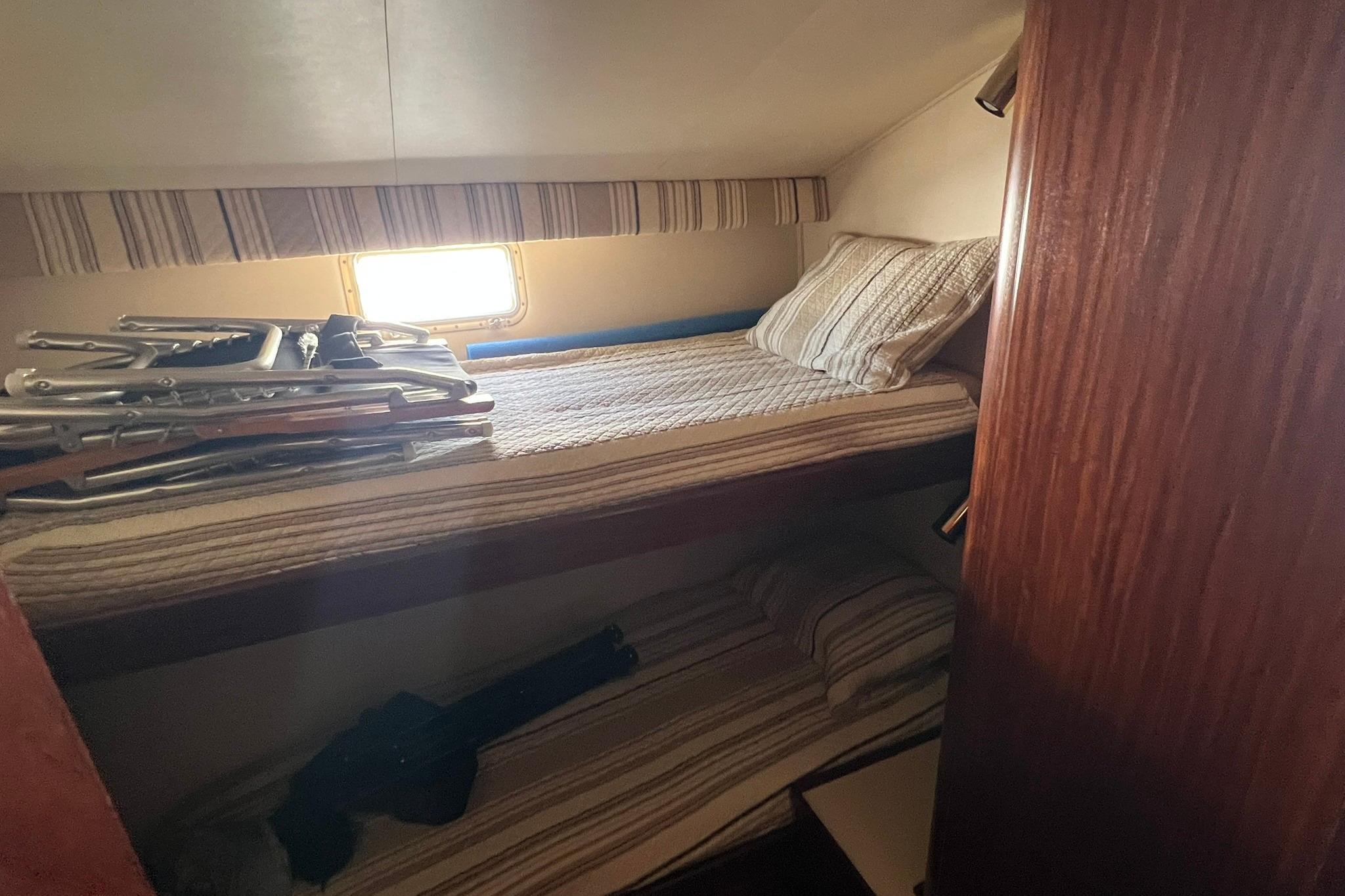 Interior cabin of 1990 Hatteras 41 Convertible with bunk beds and window.