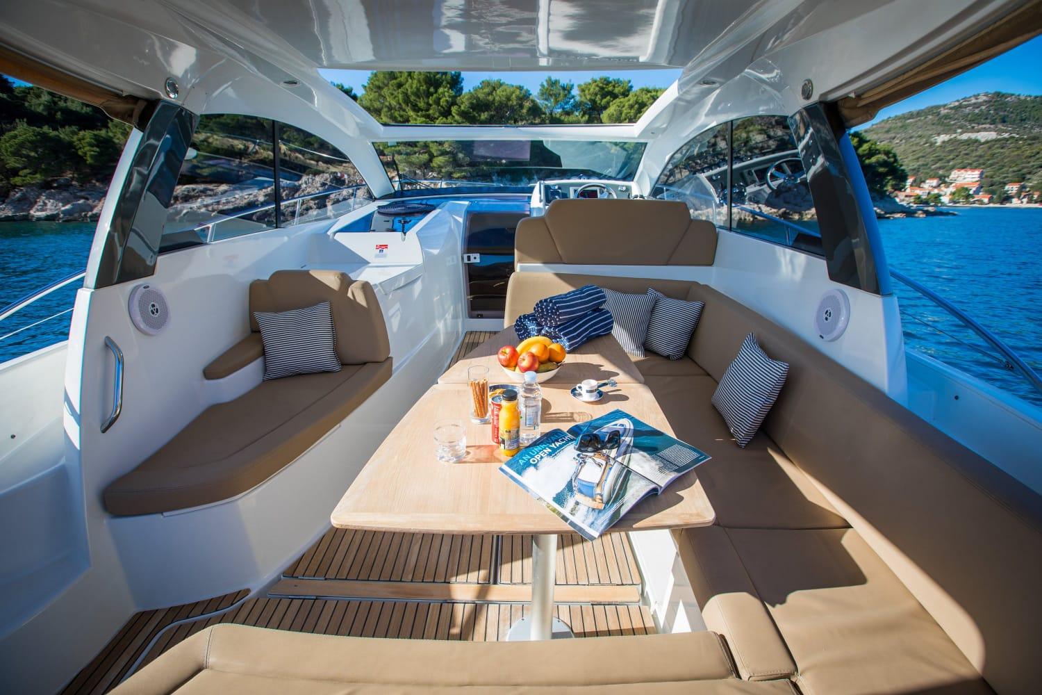Luxurious 2012 Jeanneau Leader 10 yacht interior with seating, table, and scenic ocean view.
